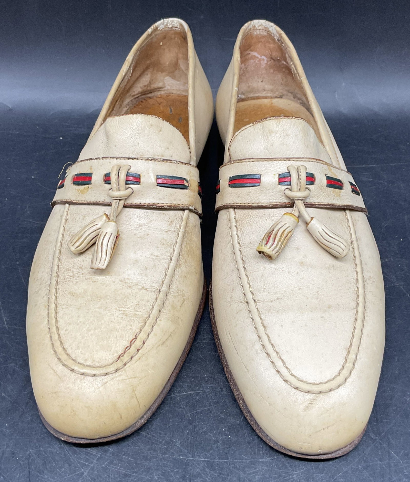 Vintage Gucci White Leather Tassel Loafers Italy: Vintage signed Gucci white leather loafers with green and red woven cord and tassel. Made in Italy. Size 42.5. Wear including scuffing, scratching, discoloration. Insoles need replacement. Gucci shoes