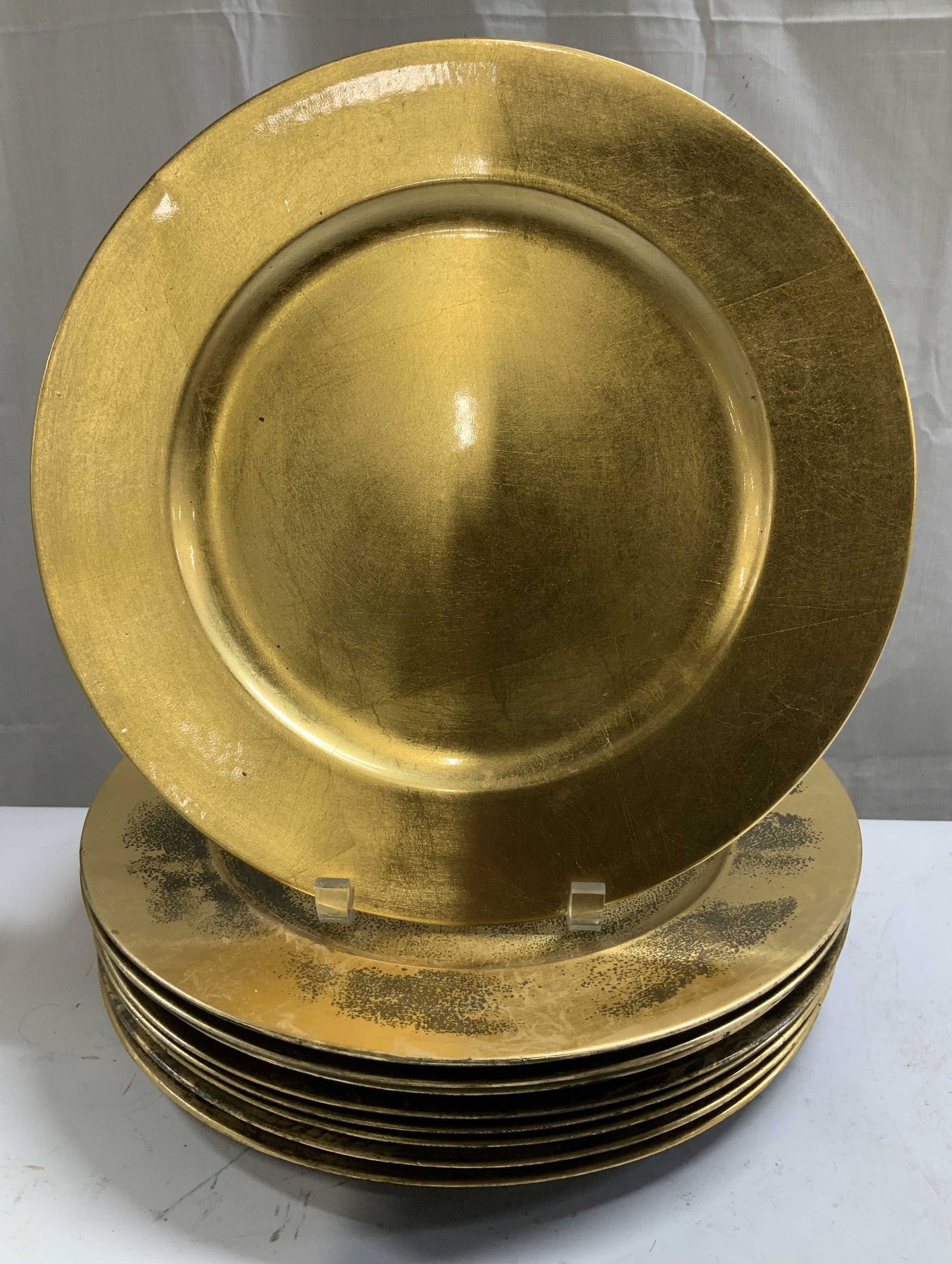 Set 9 C.1997 Decorative Gold Leaf Chargers: Lot includes, set 9 of gold leaf chargers. Plastic material. Lacquer finish. Round shape. Signed & marked. Reads, Royal Gallery. Expressly for Federated Department Stores, Inc. C.1998 & 1997. Surface 