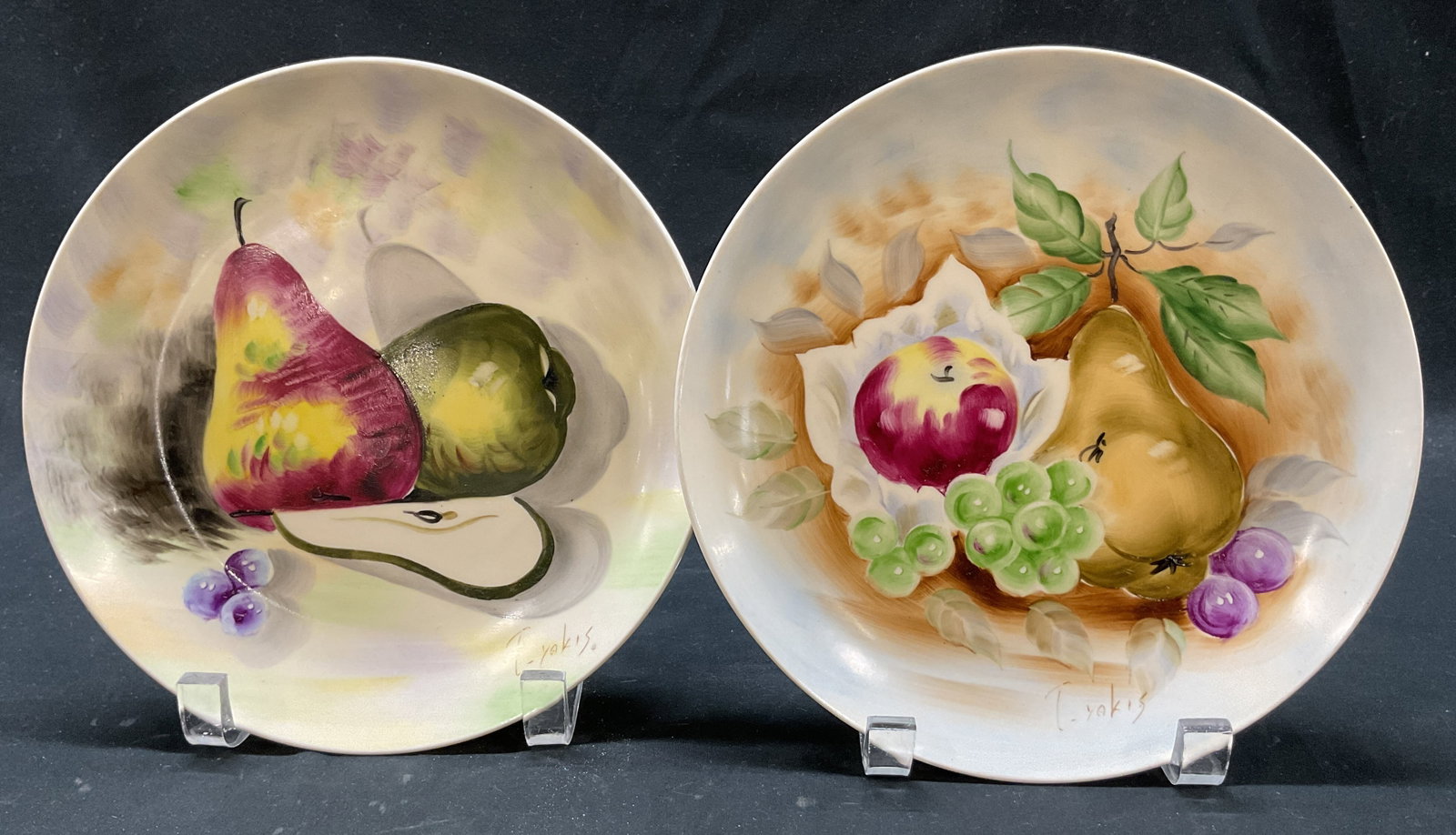 Lot 2 SGND Ceramic Hand Painted Wall Plates Japan: Lot of 2 ceramic hand painted wall plates. Marked on underside, reads Hand Painted Made In Japan. Signed on surface, reads illegibly. Round plates. Hand painted fruit motifs in varying colors. Include