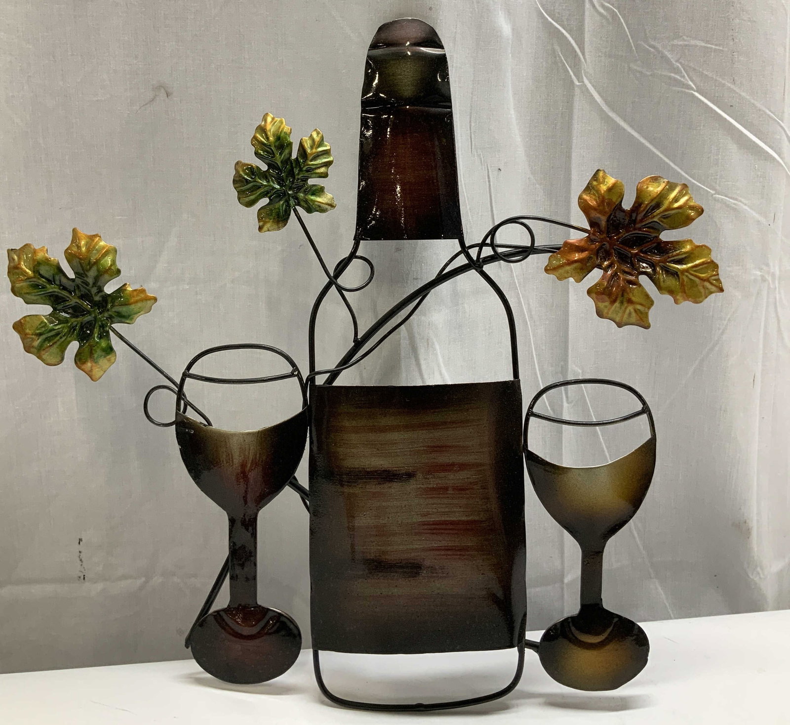 Metal Wine Home Wall Decor: Metal wall decor depicting a wine bottle & wine glasses. Floral detailing. Green, yellow, red, brown & black. No visible signature or markings. Surface wear consistent to age, use & exposure. Measurem