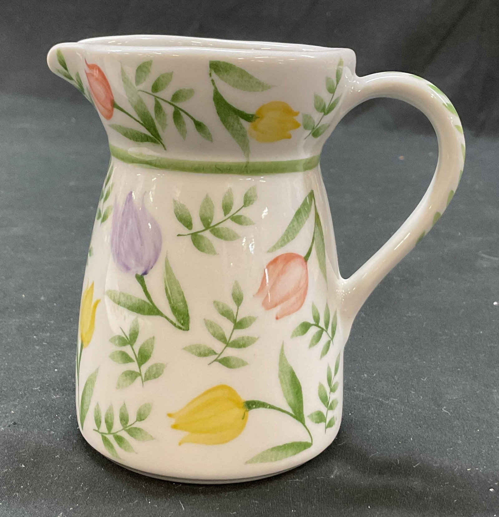 Andrea By Sedak Botanical Porcelain Creamer: Andrea by Sedak botanical porcelain creamer. Floral motifs in varying colors, botanical tulip flowers. Curved handle and spout. Measures approx 2.5 x 4 x 4 inches. Surface wear consistent with exposur