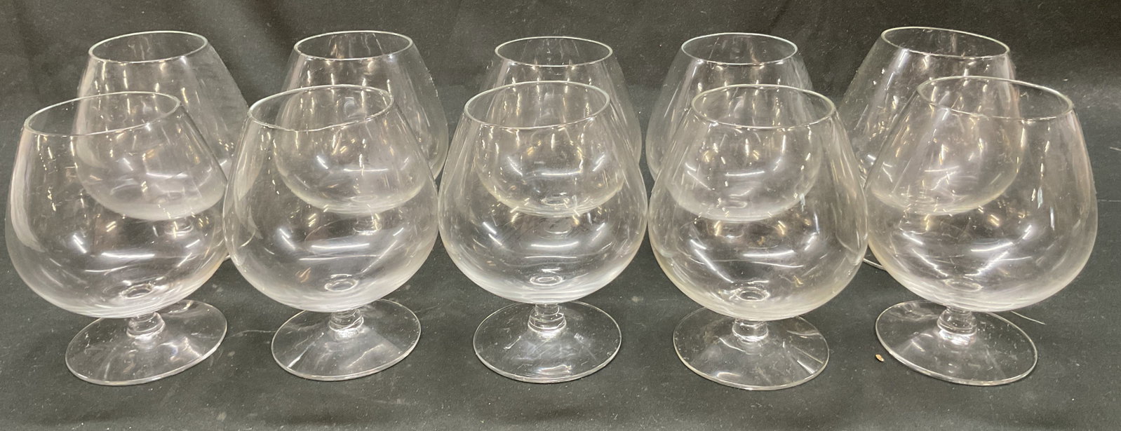 Set 10 Vintage Glass Brandy Snifters: Set of 10 vintage glass brandy snifters. Clear glass. Round base and short stem. Bulbous body and narrow rim. Measures ht approx 4.5 inches diam approx 2.5 inches. Some scratching. Brandy snifters, st