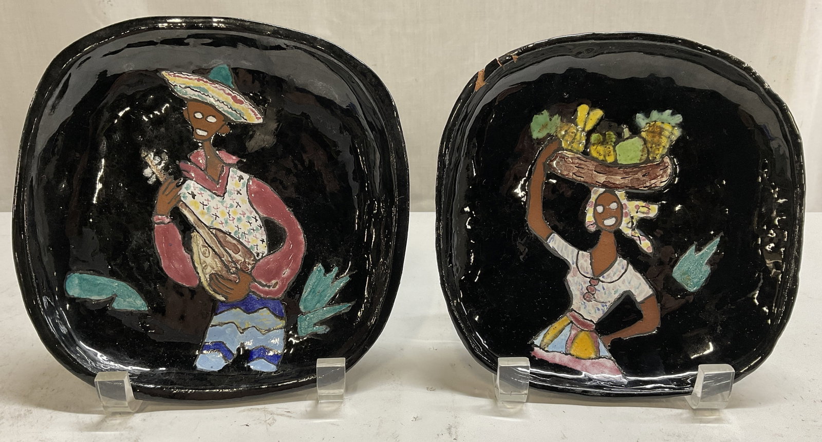 St 2 Handmade Garon Jamaica Pottery Plates: Set of 2 Handmade Garon Jamaica BWI Pottery Plates. Black Ceramic with Painted Design of a Musician and a Woman Carrying a Fruit Basket on her Head. Some chips and cracking. Measures app 1in H x 6.5in
