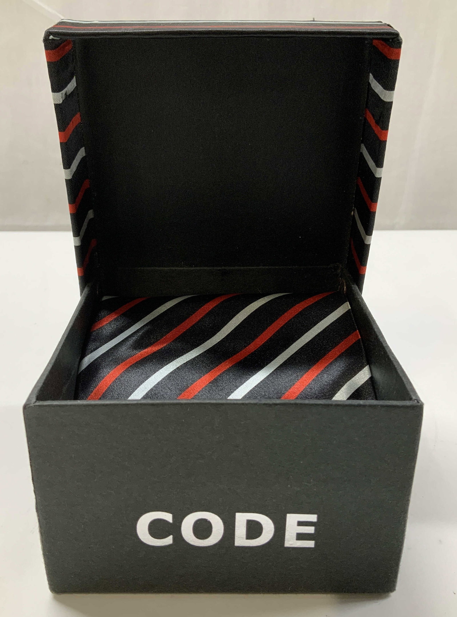 Code Striped Necktie & Handkerchief W Org Box: Lot includes, 1 necktie & 1 handkerchief. Pieces feature a black, red & white striped pattern. Comes with box. Feels like silk. Signed & marked. Reads, CODE. Surface wear consistent to age, use & expo