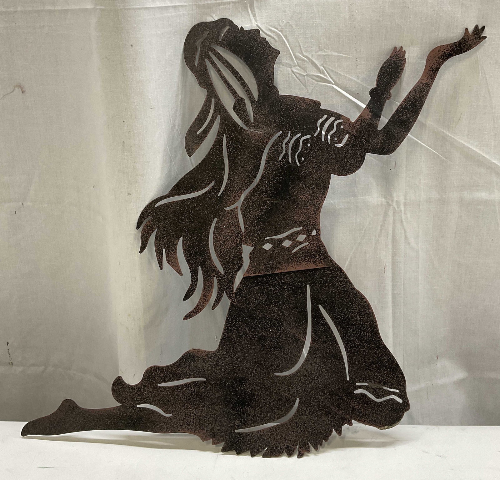 Native American Inspired Metal Wall Art 21in: Native American Inspired Metal Wall Art. Made of Layered Cut Steel. Black with Copper Speckle Pattern. Depicts a Native American Figure Kneeling with Arms Outstretched. Condition consistent with expos