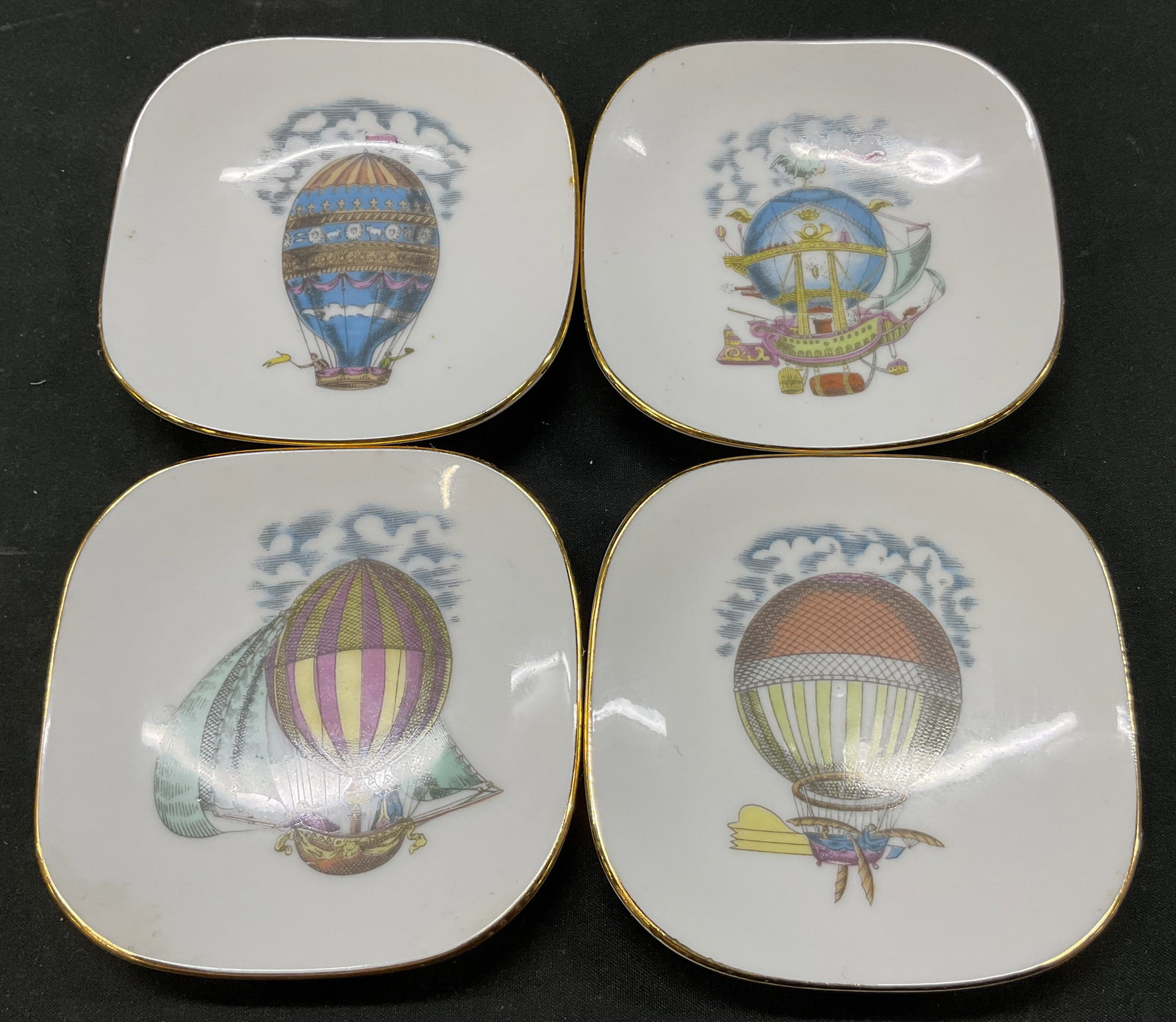 Set 4 Richard Ginori Alitalia Porcelain Plates: Set of 4 Richard Ginori for Alitalia porcelain plates. Marked Alitalia Richard Ginori on underside. Gilt rim. Imagery features hot air balloons with various motifs including figures, animals, etc. Var