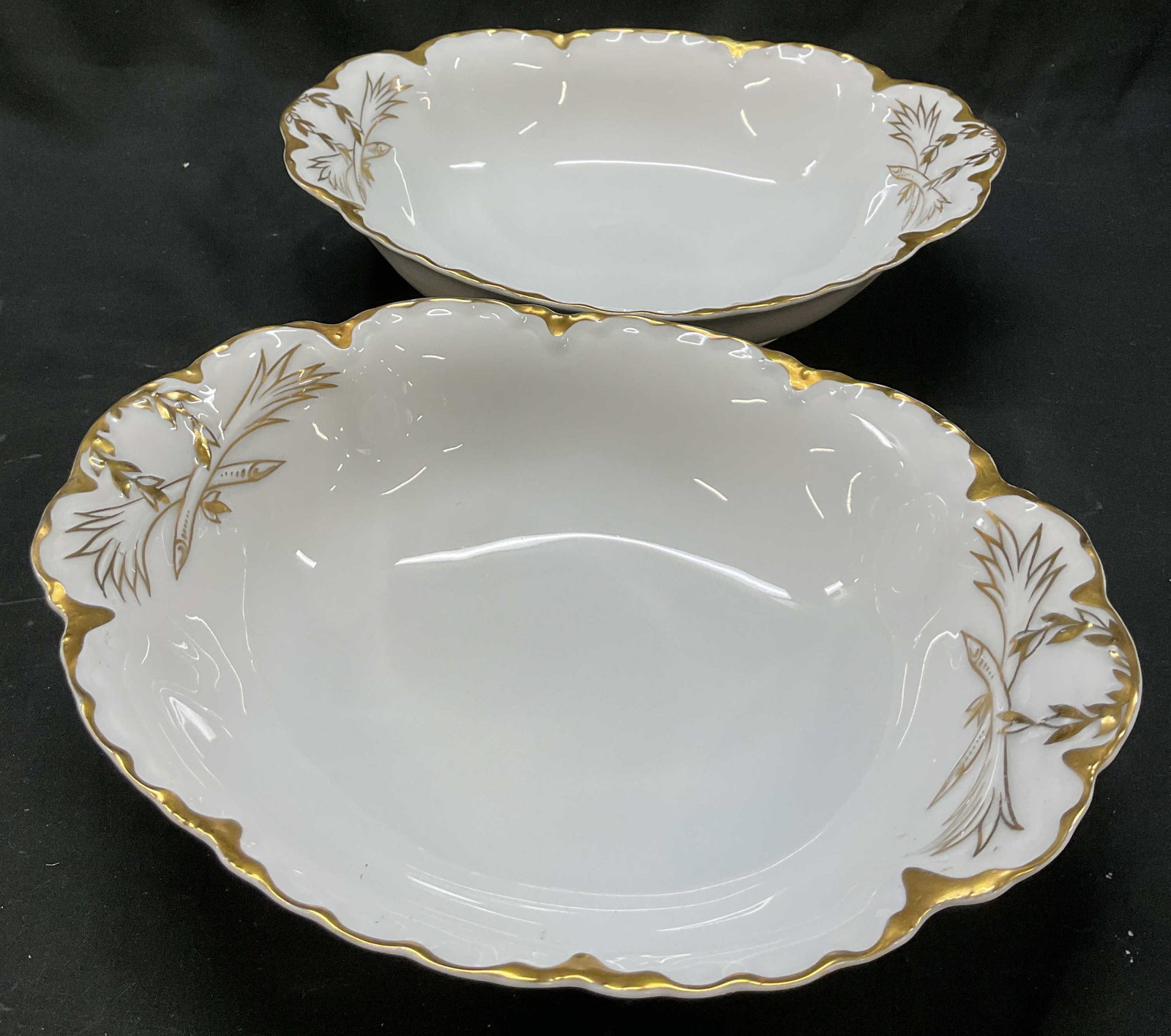 Pair Racine Bavaria Porc Serving Bowls Germany: Pair of Racine Bavaria porcelain serving bowls. Marked on underside, reads Racine Bavaria. Oval shaped bowls. Scalloped gilt rim. Decorative leaf motifs. Measures approx 8 x 10 x 2.5 inches. Surface w