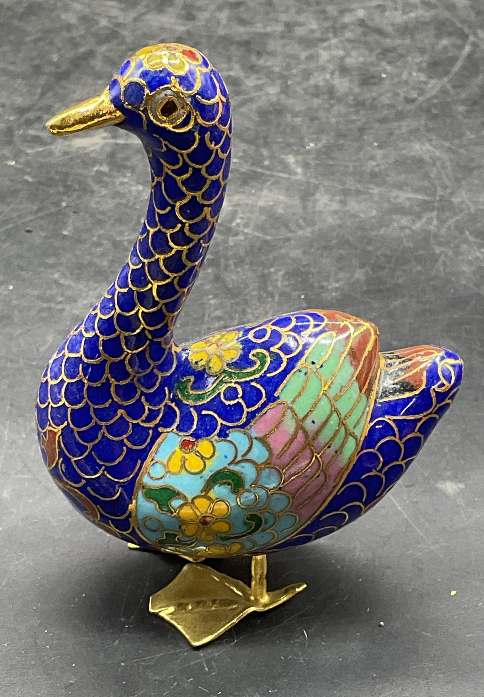 Vintage Blue Cloisonne Duck Figurine: Vintage enameled brass cloisonne duck figurine in blue with floral design. Measures approx 2.25 x 1 x 3.25 inches. Some scratching and warping. Cloisonne duck, Cloisonne figurine, decorative arts, col