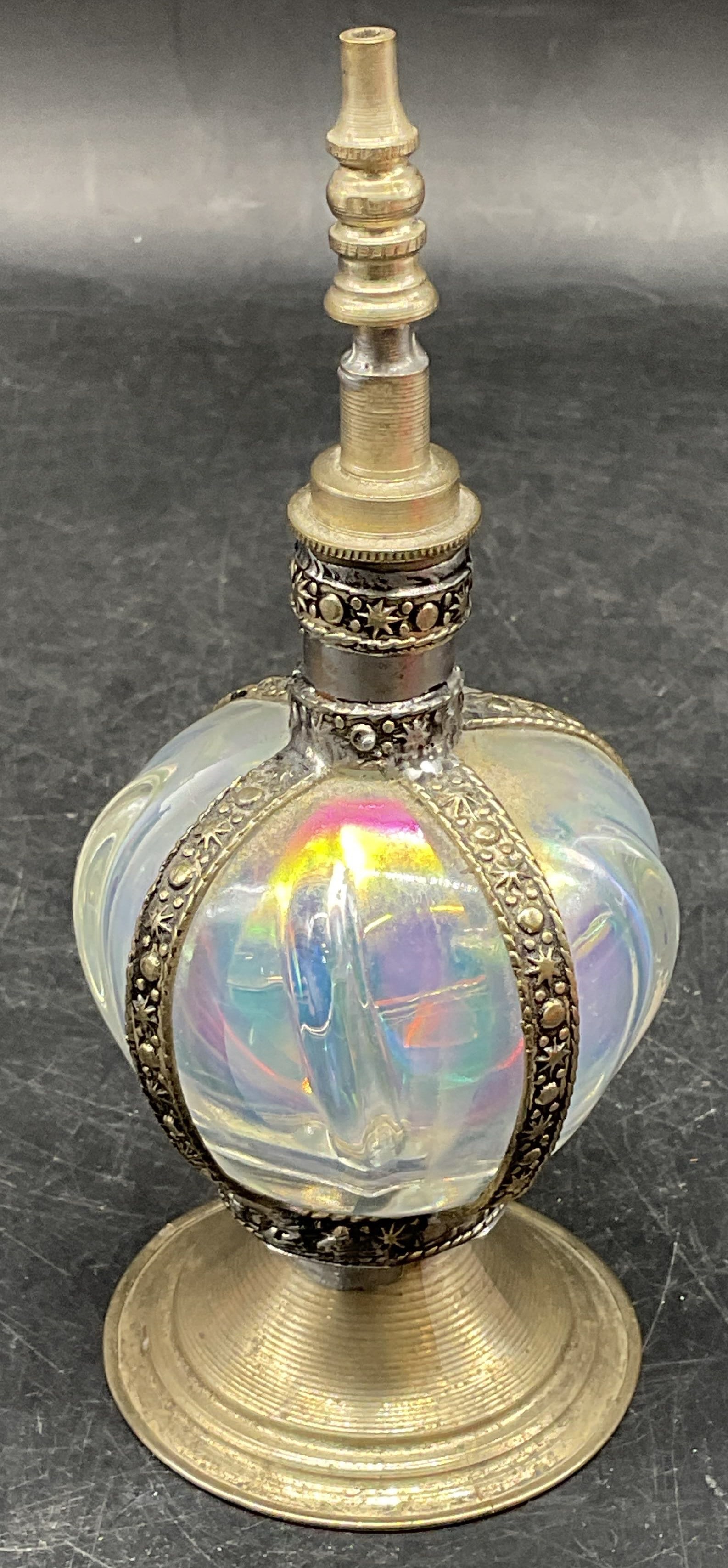 Iridescent Art Glass & Silver Plate Perfume Bottle: Iridescent white hand blown art glass perfume bottle with silver plated base, stopper, and frame. Measures approx. 2.5 x 6.25 inches including stopper. Wear including patina and scratching. Art glass 
