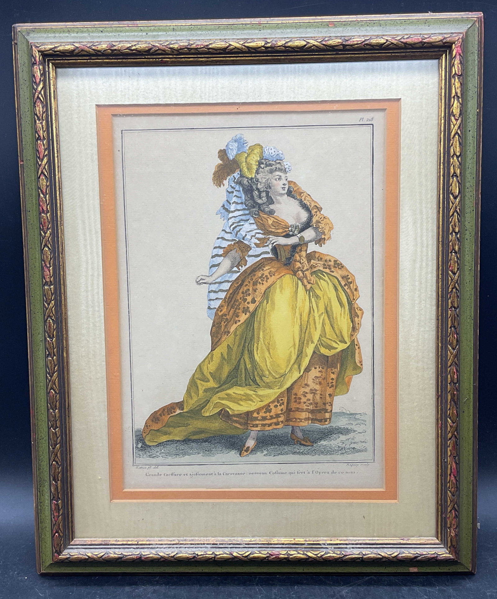 After Watteau Antique French Fashion Engraving: Framed antique hand colored engraving. After Louis Joseph Watteau. French fashion, woman wearing orange and yellow gown. Green and gilt wood frame. Not examined out of frame. Frame measures approx. 16