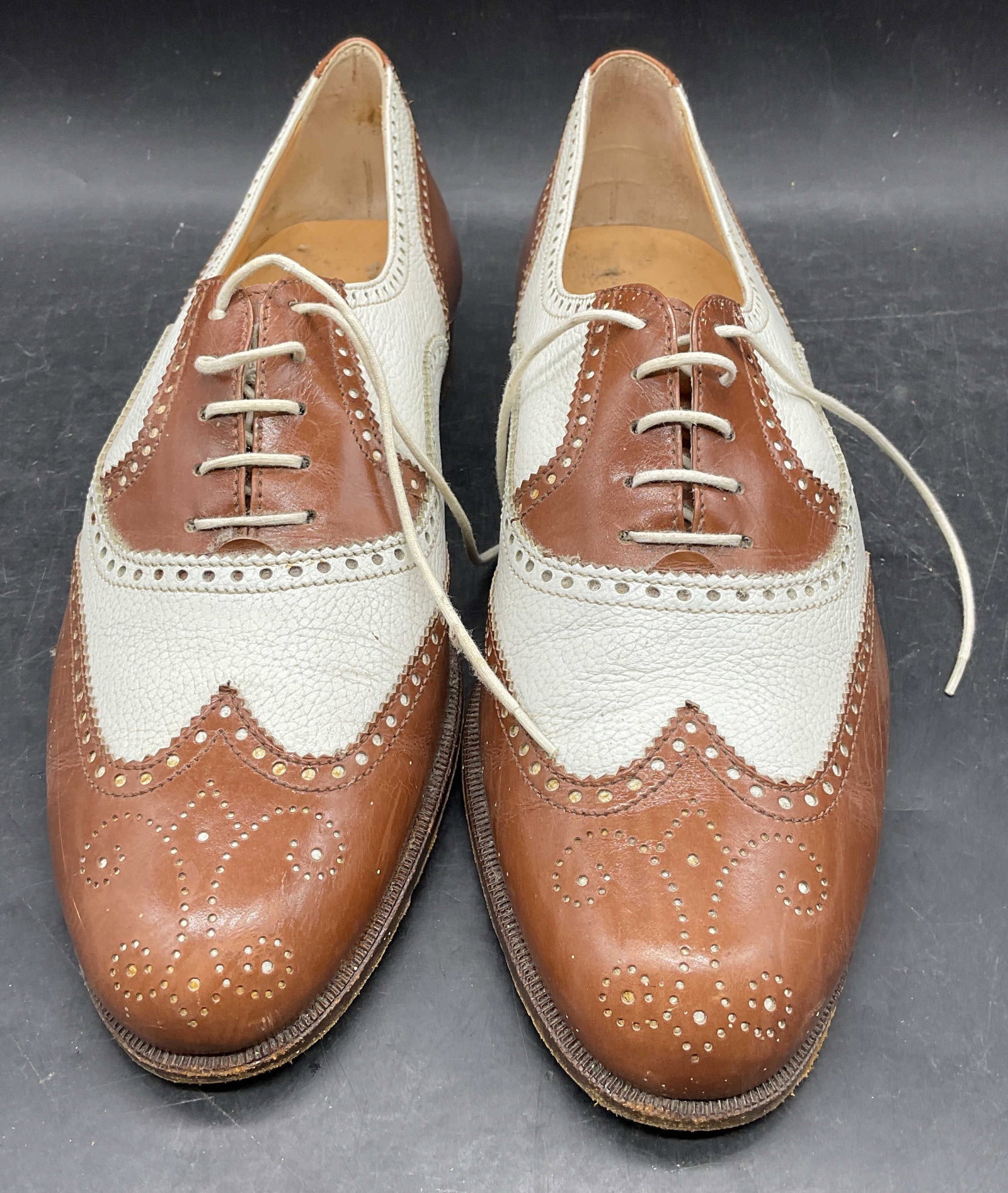 Cole Haan Brown Leather Wingtip Shoes ITALY: Cole Haan brown and white perforated leather wingtip shoes. Made in Italy. Size 9.5. Some scratching and scuffing. Cole Haan shoes, designer shoes, wingtip shoes, spectator shoes, leather shoes, brown