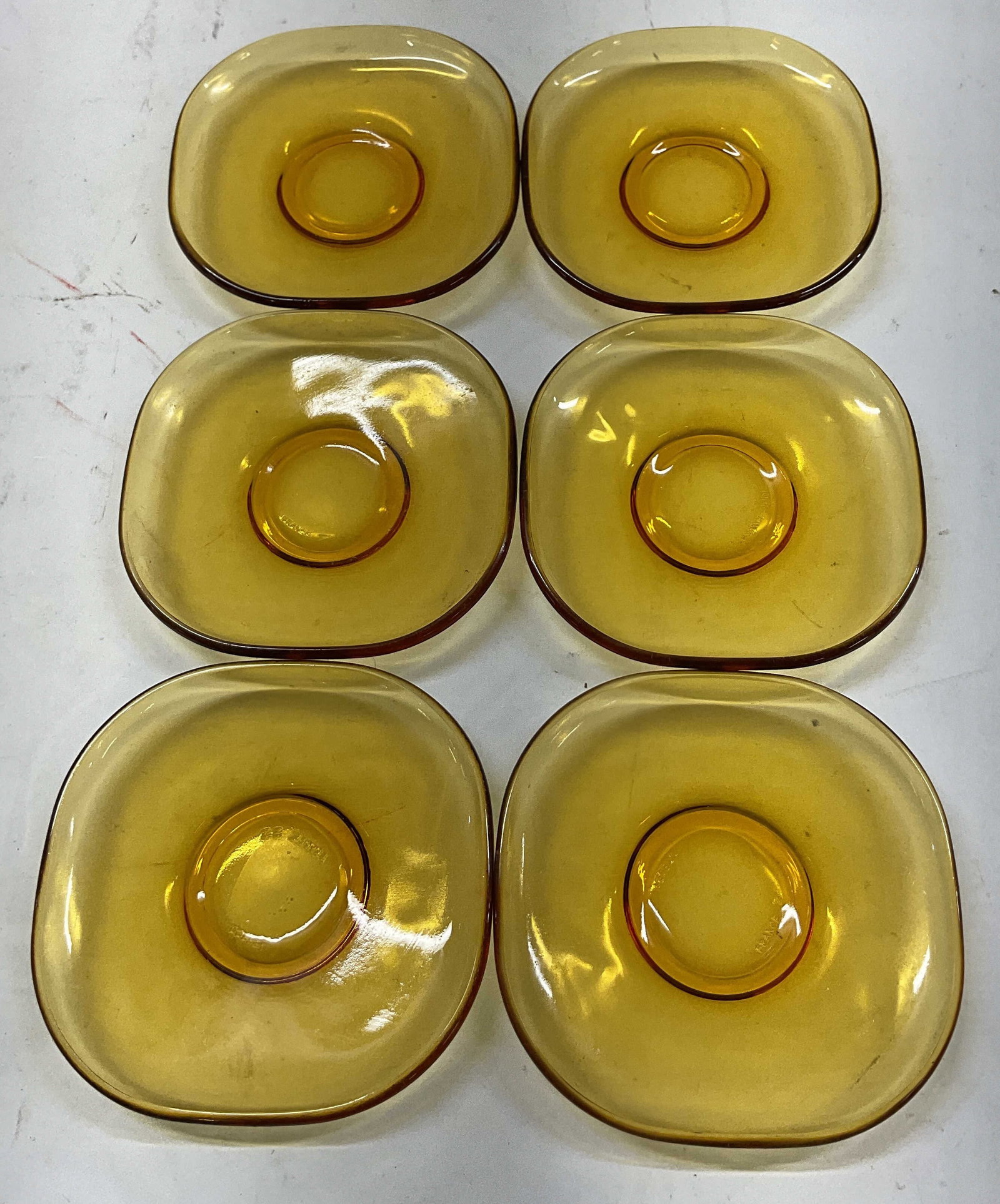 Set 6 Vereco Amber Glass Saucers France: Set of 6 Vereco amber glass saucers. Marked Vereco France on underside. Square shaped with curved edges. Amber tone. Measures approx 4 x 4 inches. Some scratching. Saucers, Vereco, tableware, home dec