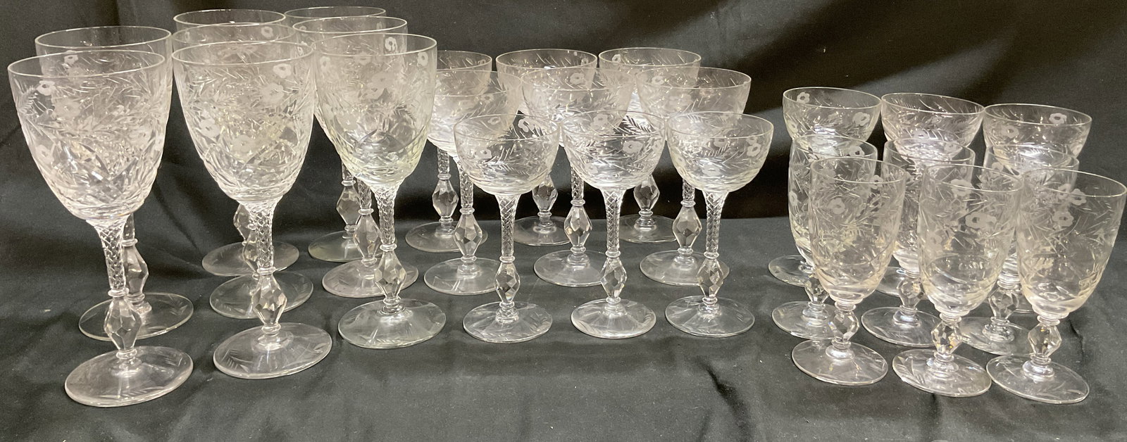 Grp Lot 26 Assorted Water & Wine Crystal Goblets: Group lot of 26 assorted water and wine crystal goblets. Etched floral and leaf motifs. Twisted stem with faceted diamond shape accent. Round base. Shapes and size vary. Tallest measures ht approx 8 i