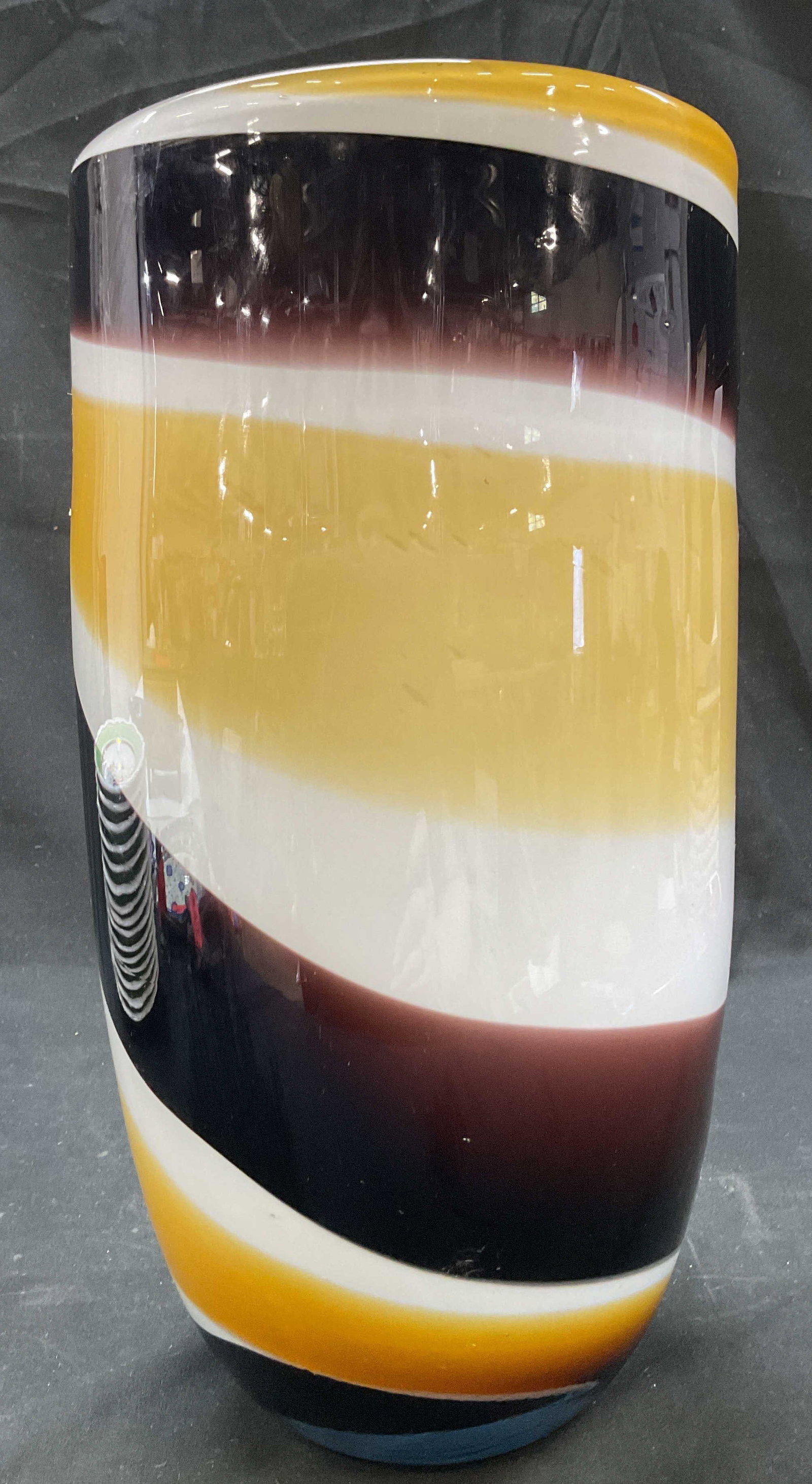 Murano Style Hand Blown Swirl Art Glass Vase: Murano style hand blown swirl art glass vase. Tall cylindrical shape. Swirled pattern in white, yellow, and dark brown. Glossy finish. Measures ht approx 13.5 inches diam approx 6.5 inches. Surface we