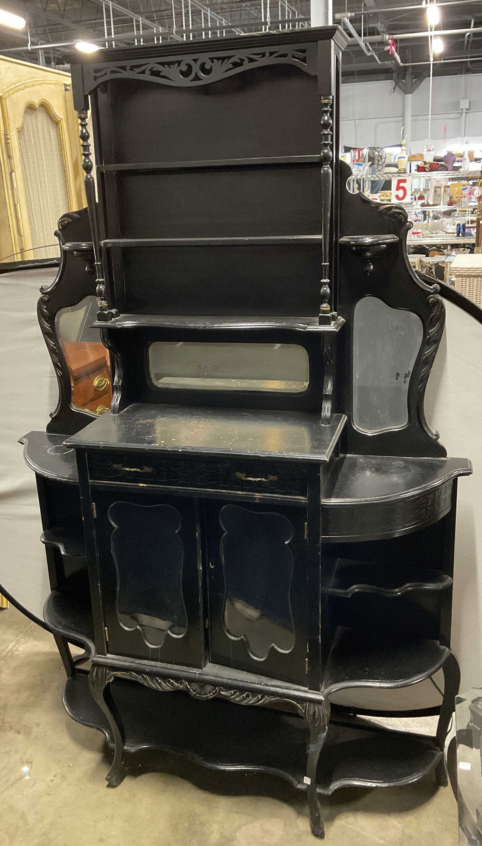 Vtg Black Wooden Mirrored Parlor Cabinet 75in: Vintage Victorian style black wooden mirrored parlor cabinet. Upper portion has three shelves with decorative scroll accent. Bulbous stems. Curved out sides with abstract shaped mirrors. Features thre