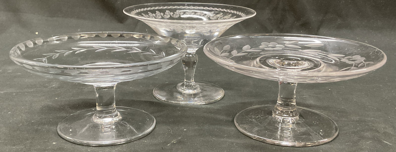 Lot 3 Vtg Etched Glass & Crystal Pedestal Compotes: Lot of 3 vintage etched glass and crystal pedestal compotes. Round base. Thick stem. Round wide dish. Etched floral and scroll motifs. Size and shape vary. Largest measures ht approx 3.5 inches diam a