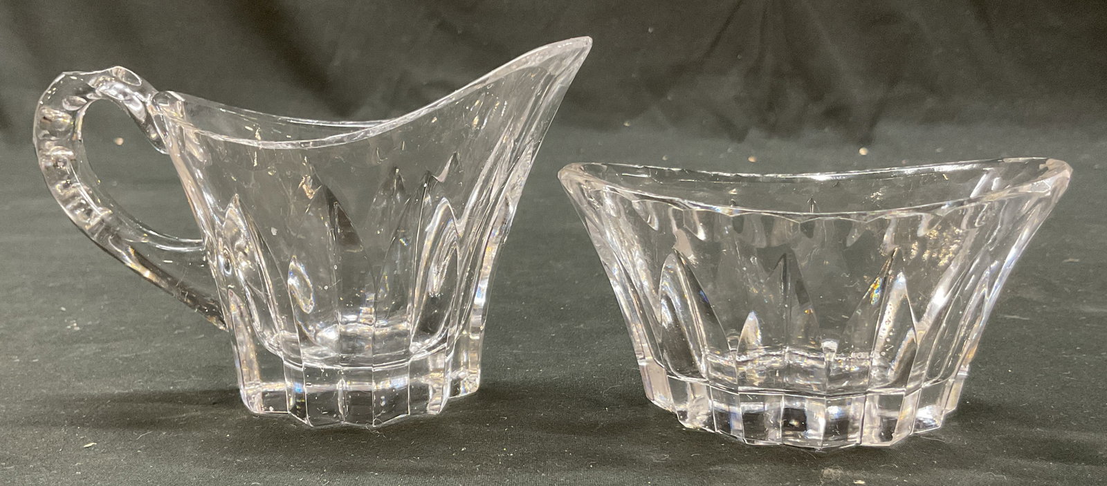 Lot 2 Vintage Crystal Creamer & Bowl: Lot of 2 vintage crystal creamer and bowl. Oval shaped. Curved handle. Sawtooth edge base. Cut geometric pattern. Largest measures approx 2.5 x 4.5 x 3 inches. Some scratching. Creamer, bowl, salt cel