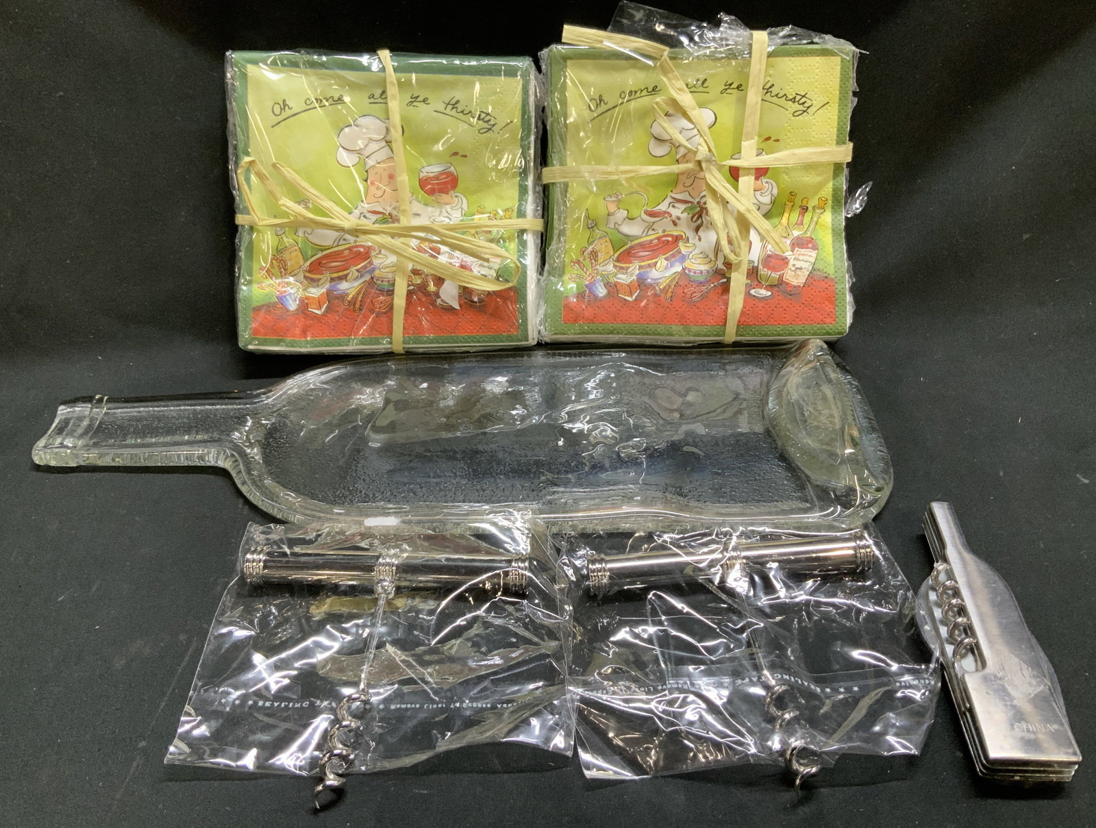 Lot 54 Cheese Board, Napkins & Corkscrews: Lot includes, 1 flat glass wine bottle cheese tray, 50 count Mud Pie Christmas chef napkins & 3 corkscrews. Sold as is. Surface wear consistent to age, use & exposure. Signed & marked. Reads, MUDPIE. 