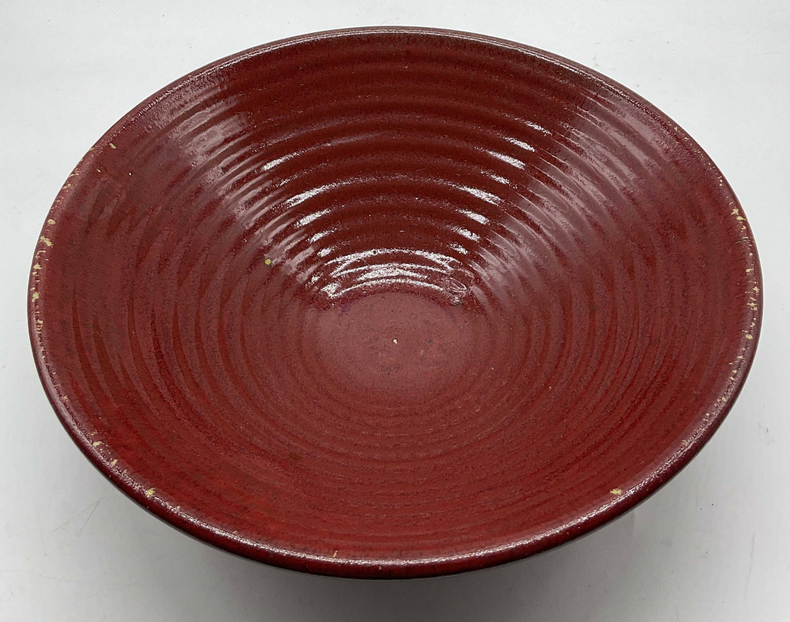 Vintage Red Ceramic Centerpiece Bowl: Vintage red ceramic centerpiece bowl. Round bowl. Ribbed surface. Glossy finish. Measures ht approx 3.5 inches diam approx 11 inches. Some chipping to paint. Bowl, centerpiece bowl, tableware, home de