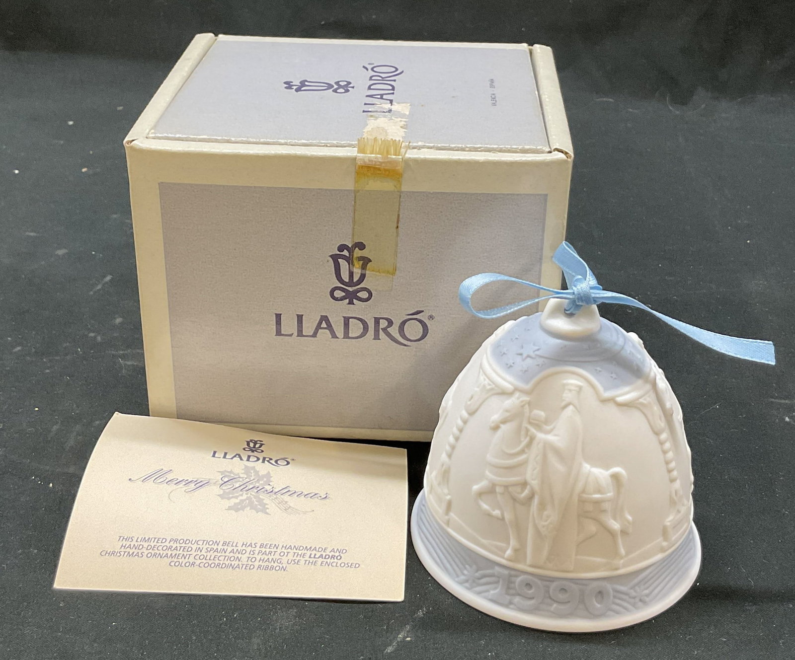 1990 Lladro Porc Xmas Bell Ornament Spain W Box: 1990 Lladro Annual porcelain Christmas bell ornament. Marked on underside, made in Spain. Comes in original box. Bell ornament in white and blue. Features imagery of The Three Kings (Three Wise Men) r