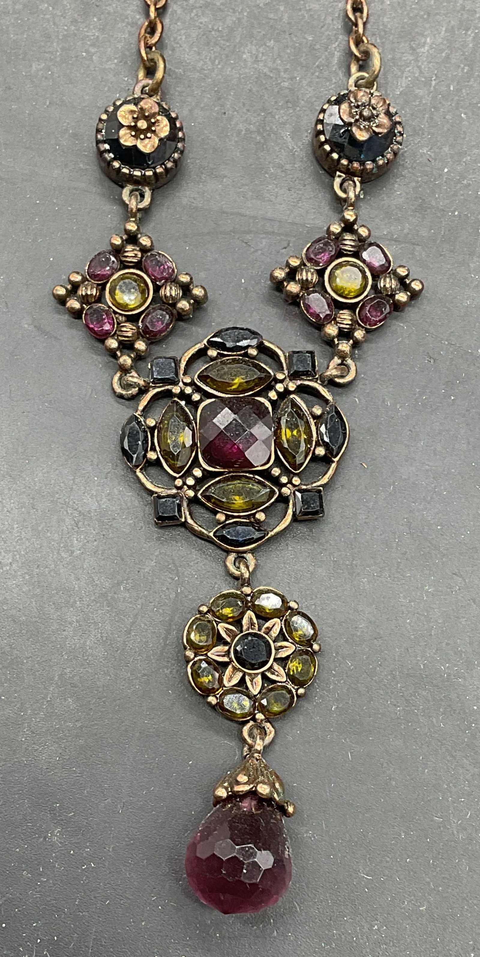 Vtg Gold Tone Green Purple Crystal Necklace: Vintage gold tone pendant necklace with purple and green crystals. Drop length measures approx. 8.5 inches. Some scratching. Jewelry, estate jewelry, costume jewelry, cocktail jewelry, fashion jewelry