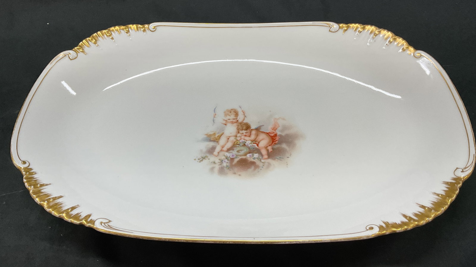 R. Delinieres & Co Limoges Cherub Platter France: R. Delinieres & Co Limoges porcelain cherub platter. Marked on underside, reads R. Delinieres & Co Limoges D & C France. Oval shaped platter. Scalloped and ribbed gilt accents. Cherub motifs in center