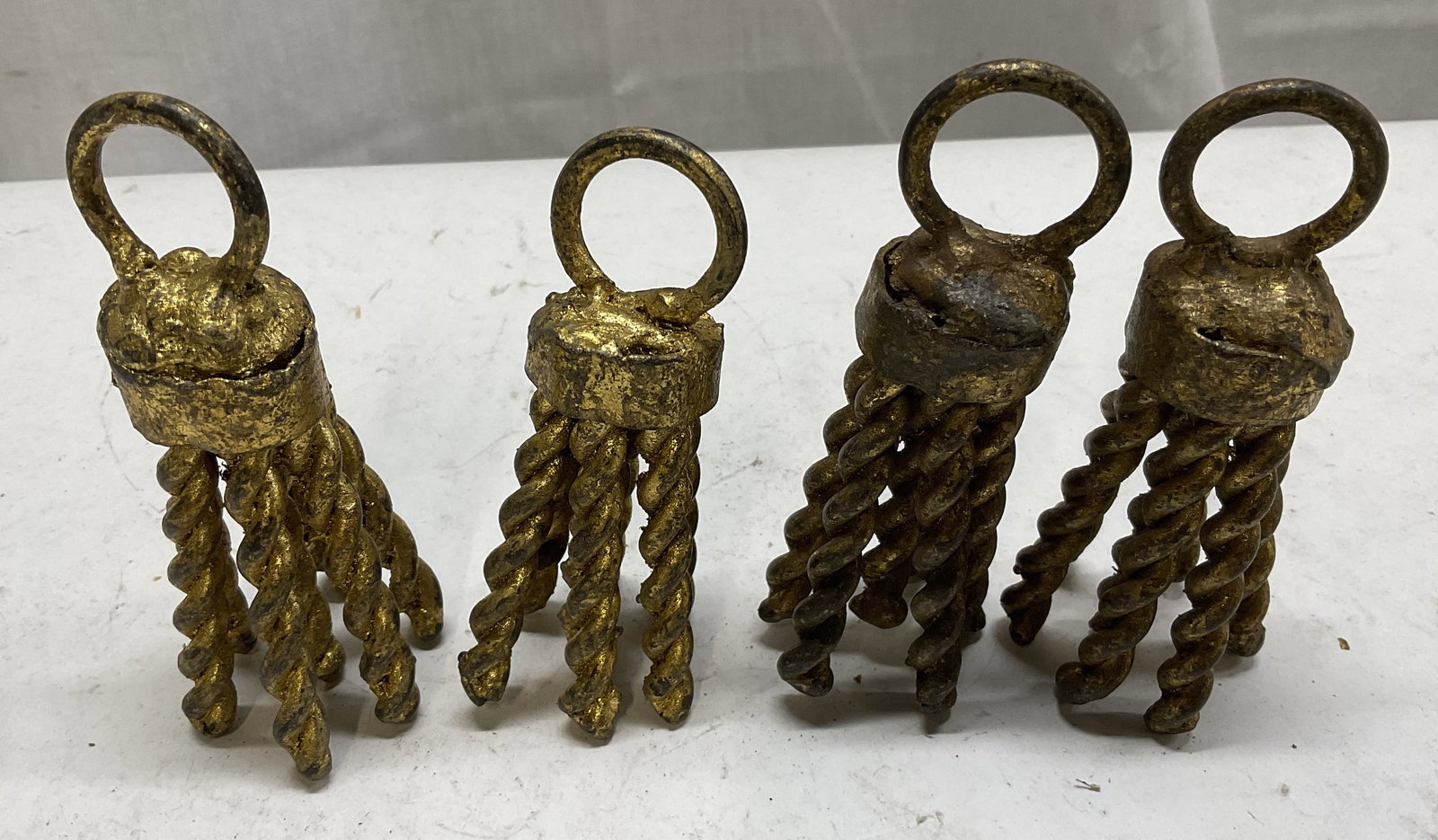 Lt 4 Painted Gilt Iron Tassel Curtain Accessories: 4 Painted Gilt Iron Curtain Accessories. Tassel Design. Surface Wear Such as Tarnishing and Chips to Paint Present. Measures app 4in H x 1.5in W. Painted Gilt Tassles, Vintage, Metal Tassels, Iron Tas