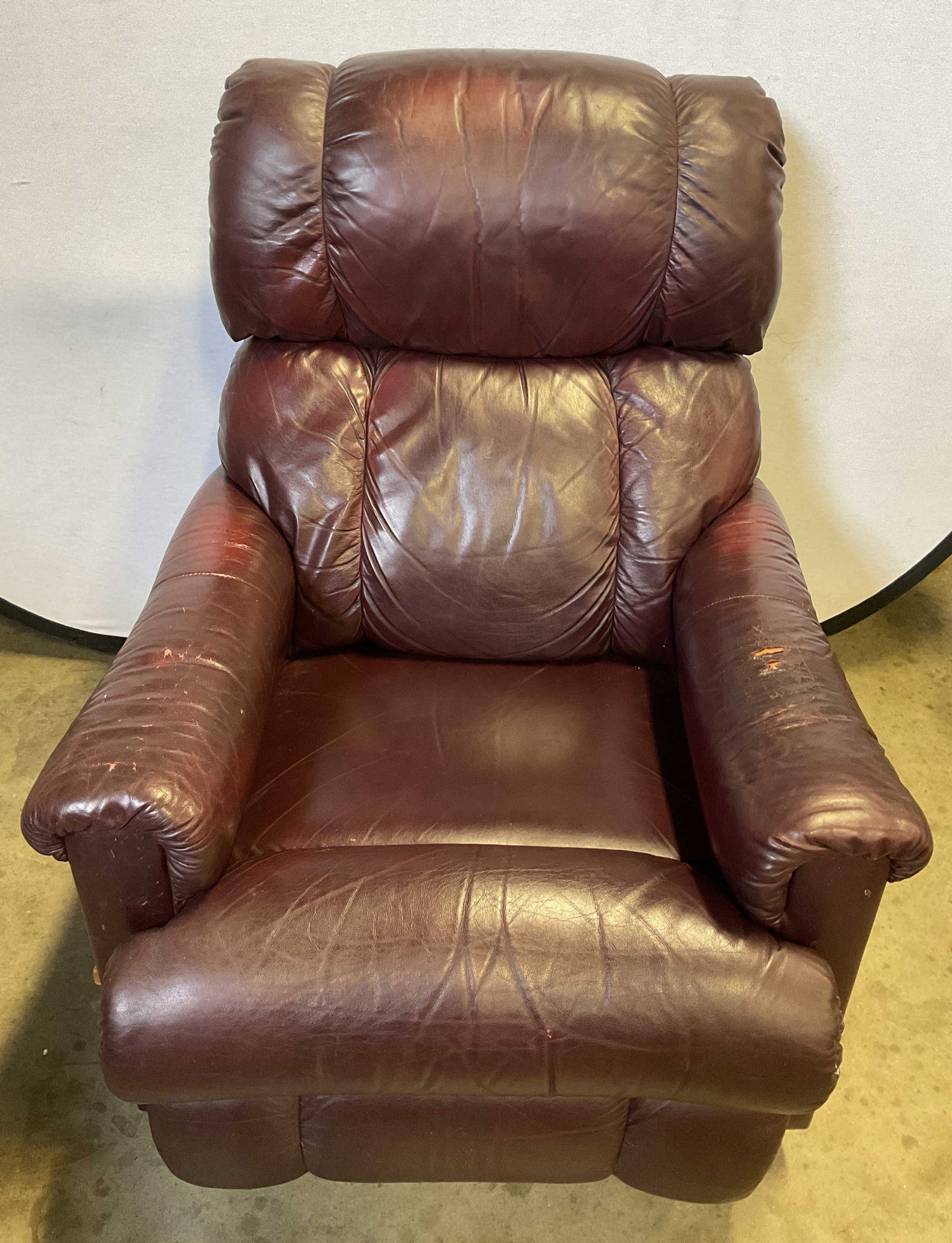 La Z Boy Burgundy Leather Rocker Swivel Recliner: La Z Boy burgundy leather rocker swivel recliner. Segmented backrest, padded armrests, chaise style footrest. Adjustable and extendable movements. Measures approx 33 x 37 x 41 inches. Wear and ripping