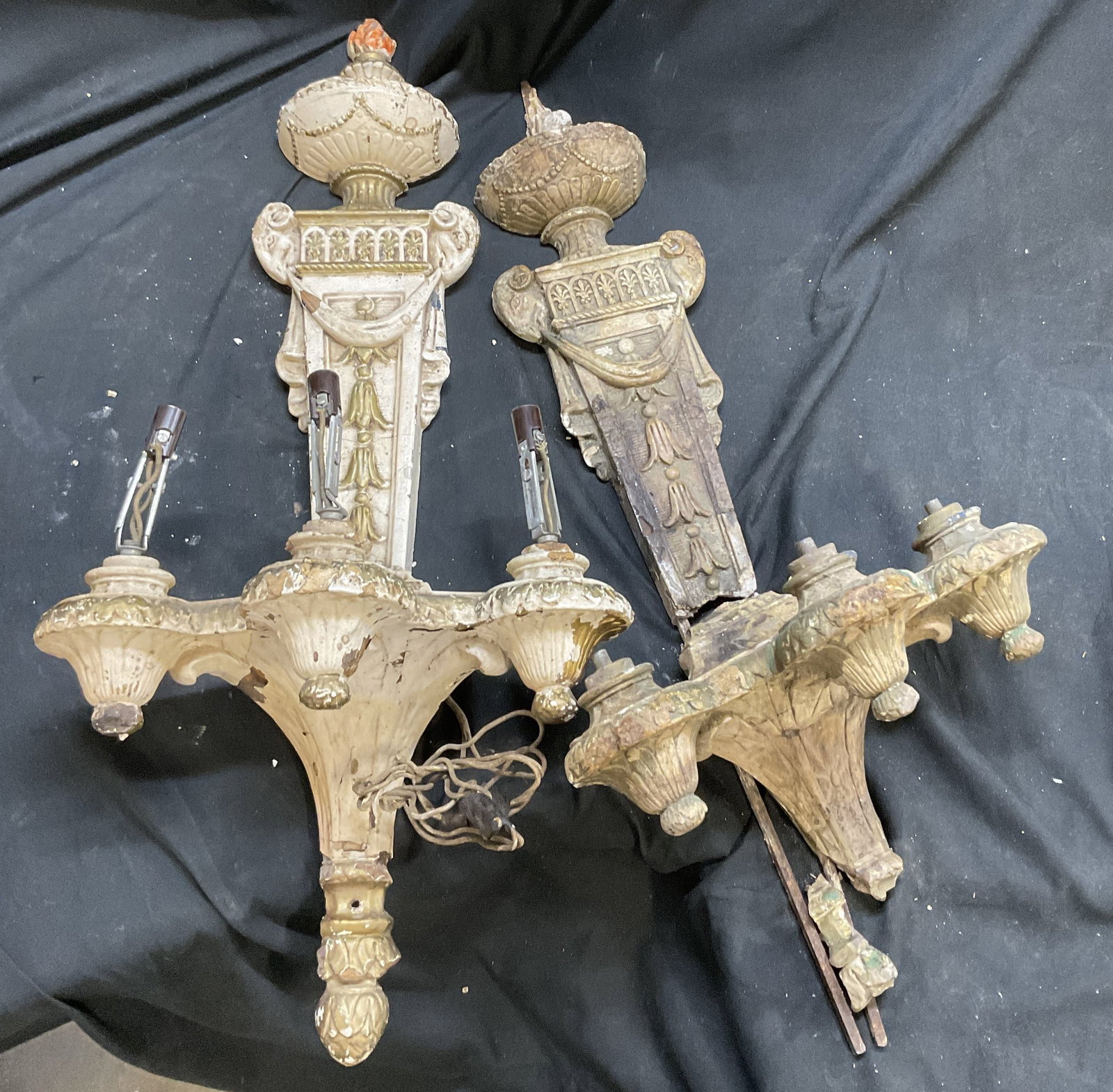 Pr Hollywd Reg Style Plaster&Wood Wall Sconces 29i: Pair of Hollywood Regency Style Plaster Over Wood Wall Sconces. 3 Light Sockets. White & Gilt Paint. Ram Head Accents. Orange Flame Torch Design on One. Significant Surface Wear, Paint Chipping, and D