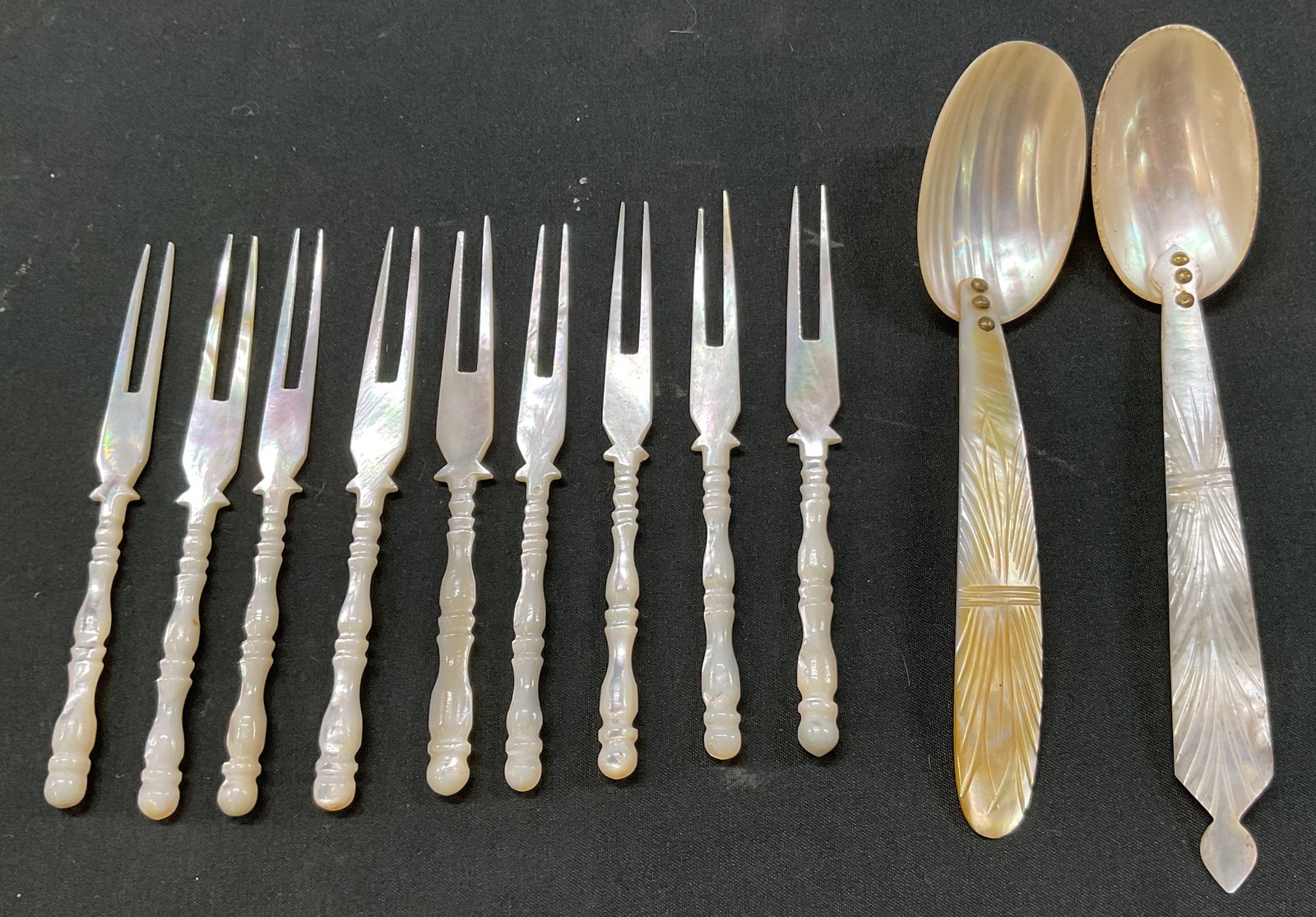 Set 11 Mother Of Pearl Cocktail Forks & Spoons: Set of 11 mother of pearl cocktail forks and spoons. Includes 9 cocktail/hors deuvres forks and 2 spoons. Mother of pearl material. Largest measures approx 6 inches in diameter. Surface wear consisten