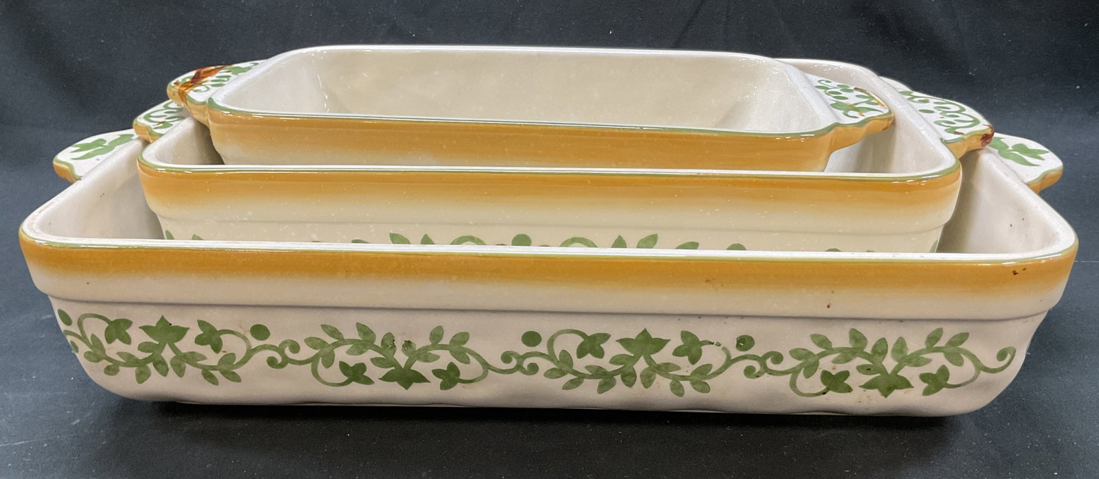 Set 3 Lidia Stoneware Painted Casserole Dishes: Set of 3 Lidia stoneware hand painted casserole dishes. Marked Lidia on underside. Rectangular shape with handles. Hand painted green floral motifs. Size vary. Measures approx 10 x 16 x 3 inches.