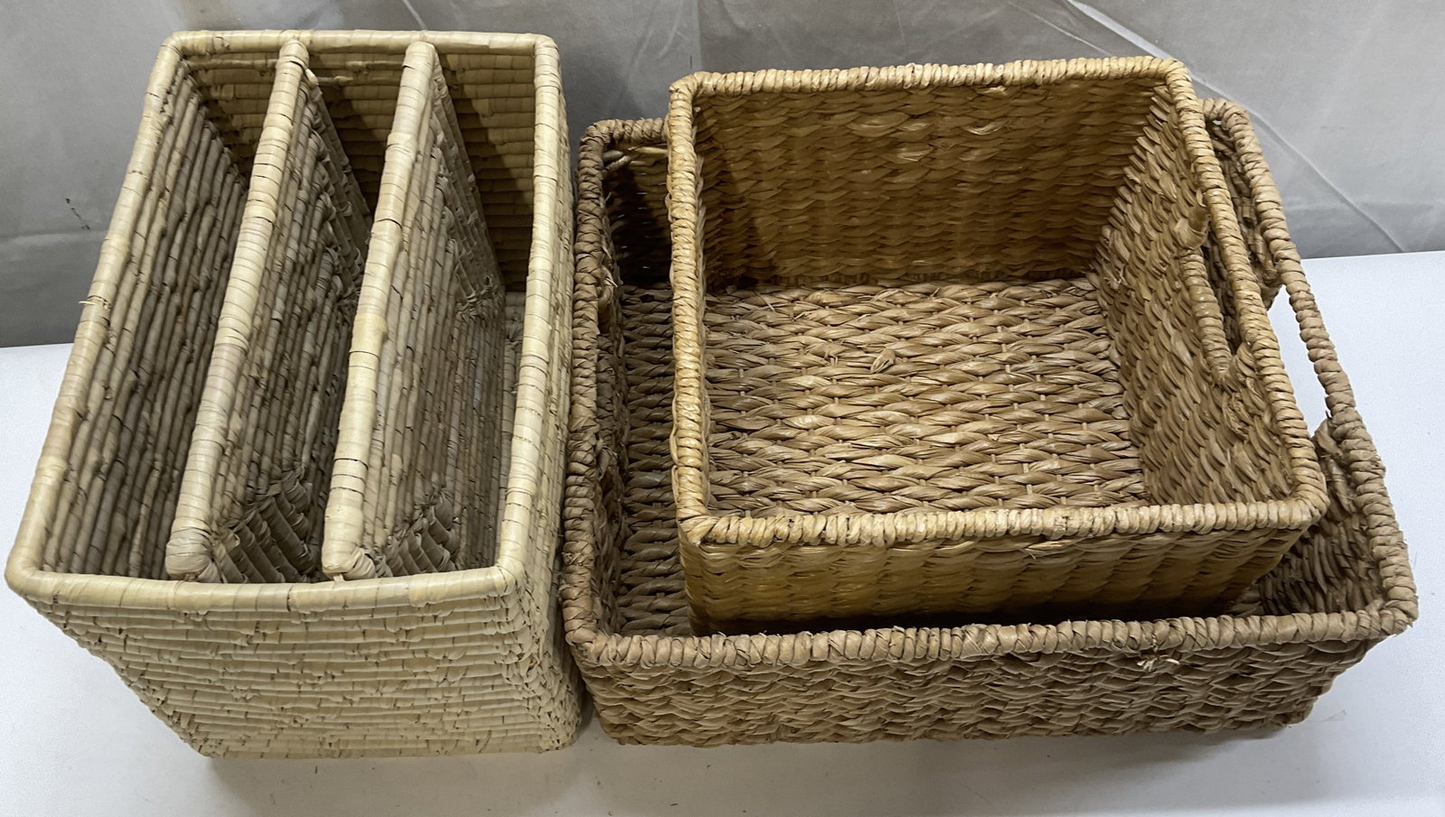 Lt 3 Woven Baskets: Lt 3 Woven Baskets. Includes Light Colored Seagrass Divided Basket, Cube-Shaped Water Hyacinth Basket with Handles, and Rectangular Water Hyacinth Basket with Handles. Some Fraying. Various Sizes. Tal