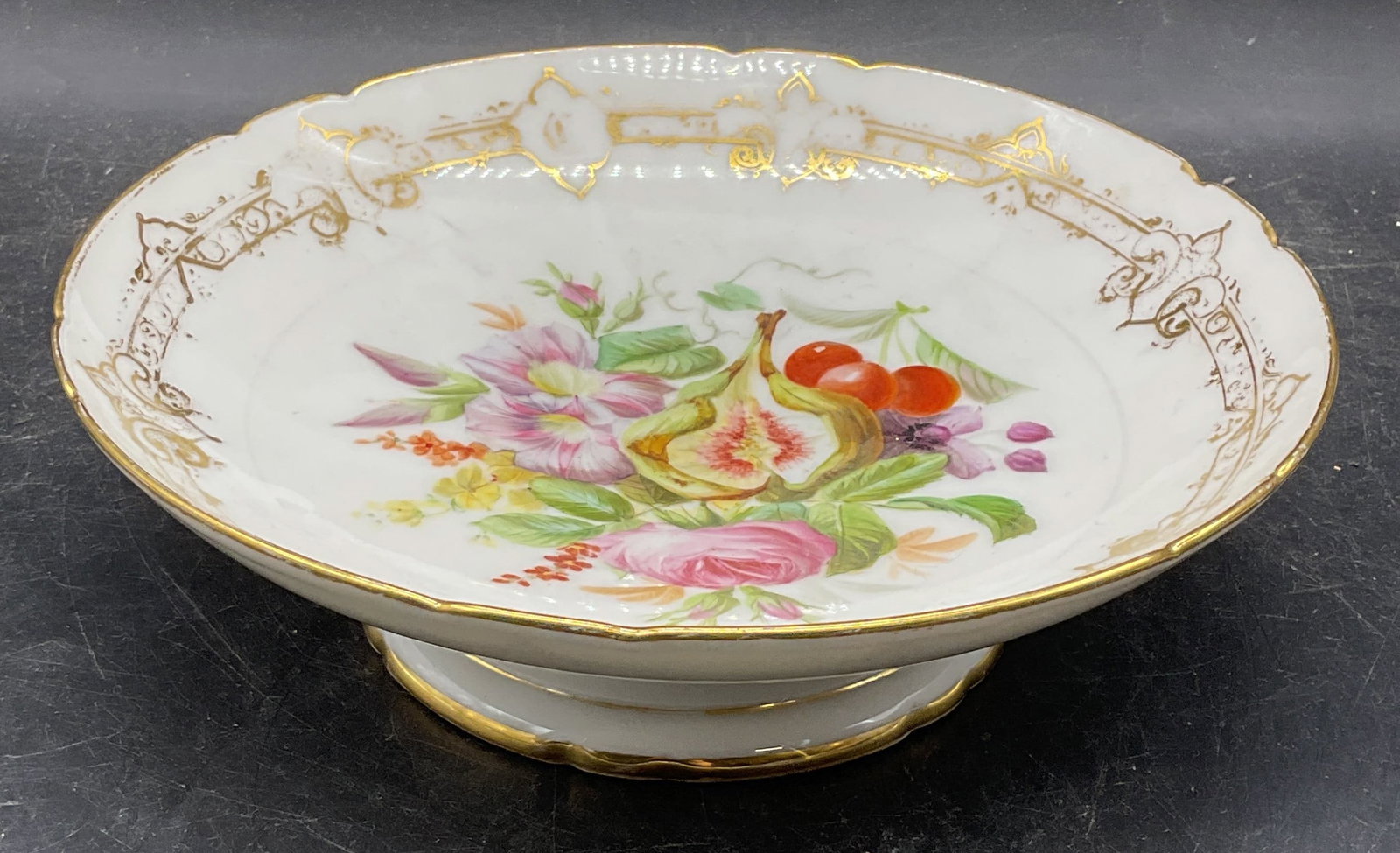 Vtg Hand Painted Fig & Flower Porcelain Bowl: Vintage, possibly antique, porcelain footed bowl. Hand painted fig and floral motif with gilt decoration. Measures approx. 8.25 x 2.5 inches. Some scratching and loss to paint. Porcelain bowl, footed 