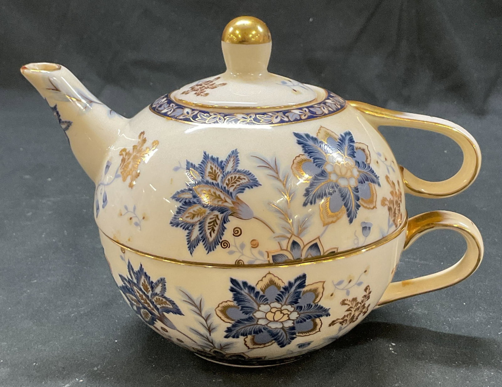 Set 2 ND Exclusive Porcelain Teacup & Teapot: Set of 2 ND Exclusive porcelain teacup and teapot with lid. Marked on underside, reads ND Exclusive. Gilt accents. Floral accents in varying colors. Measures approx 4 x 7 x 4 inches. Surface wear cons