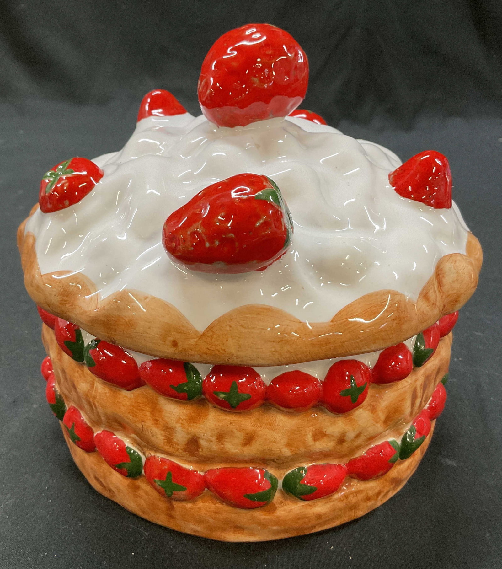 Casafina Strawberry Shortcake Cookie Jar Portugal: Casafina ceramic strawberry shortcake lidded cookie jar. Marked on underside, reads Made In Portugal For Casafina. Round cookie jar with lid. Shaped like a strawberry shortcake. Strawberry motifs. Han