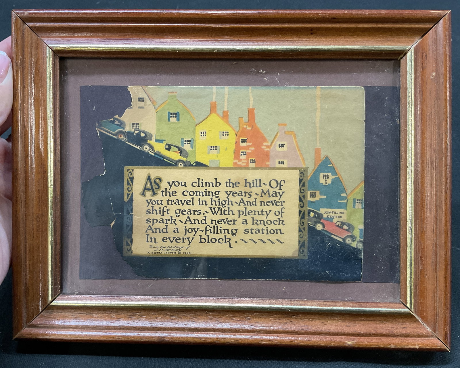 1925 Buzza Motto Framed Print W Quote: 1925 Buzza Motto framed print. Wooden frame. Whimsical Art Deco illustration of pastel roofed cottages. Features an inspirational quote of J. P. McEvoy as photographed here. Varying colors. Measures
