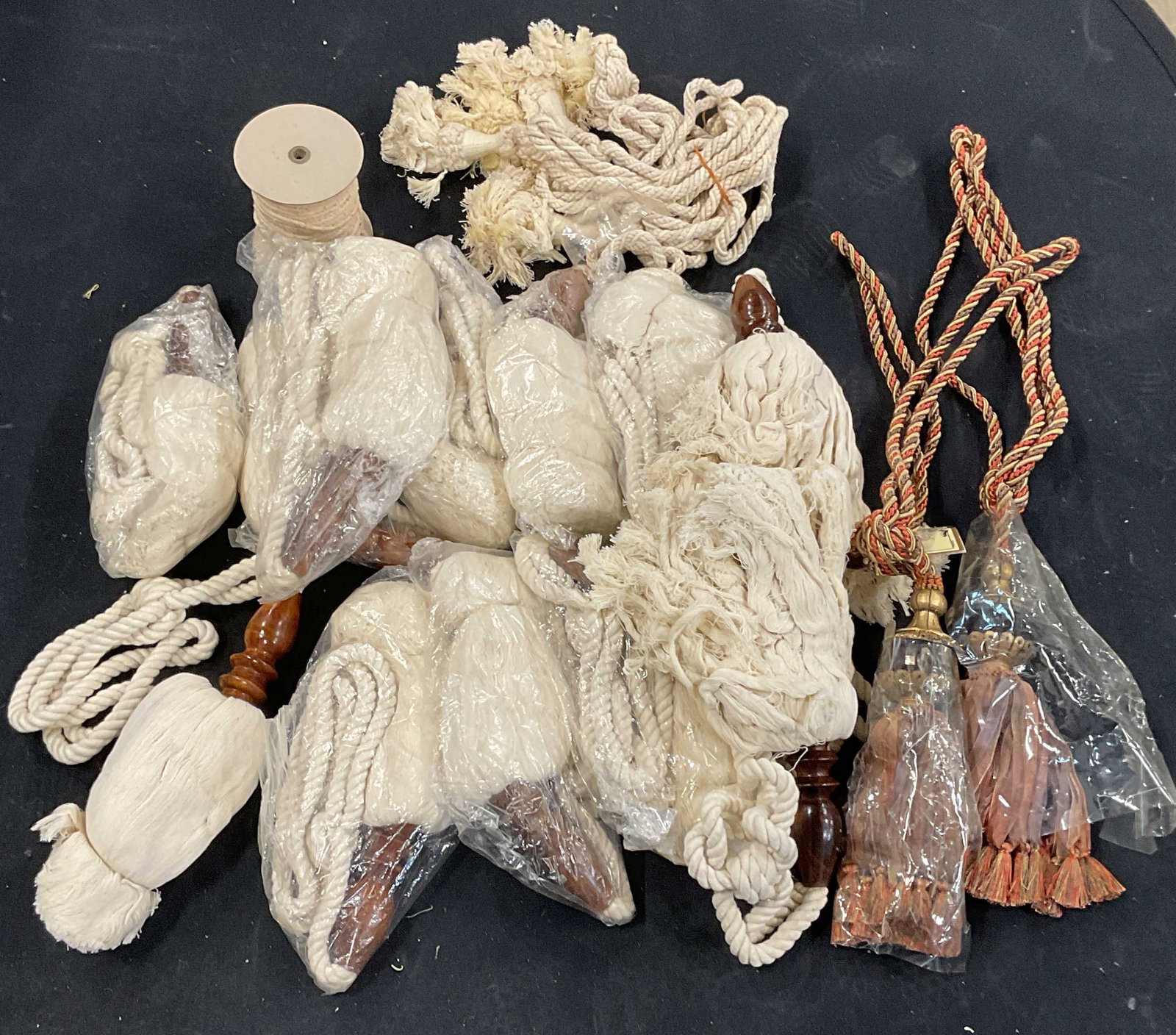 Group Lot White & Orange Tassel Curtain Trims: Group lot of white and orange/green twisted fabric and wood tassel curtain trims. Not individually examined. Not measured. Sold As Is. All pieces may contain wear consistent with exposure, blemishes, 
