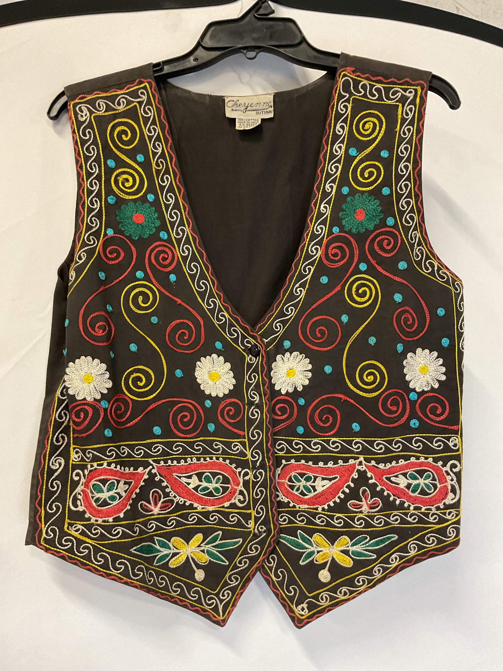 Cheyenne Autumn Embroidered Vest India: Cheyenne Autumn embroidered vest. Made in India. 100% cotton. One size fits all. Embroidered floral and scroll motifs in varying colors. Buttoned. Brown. Wear consistent with exposure. Property of ope