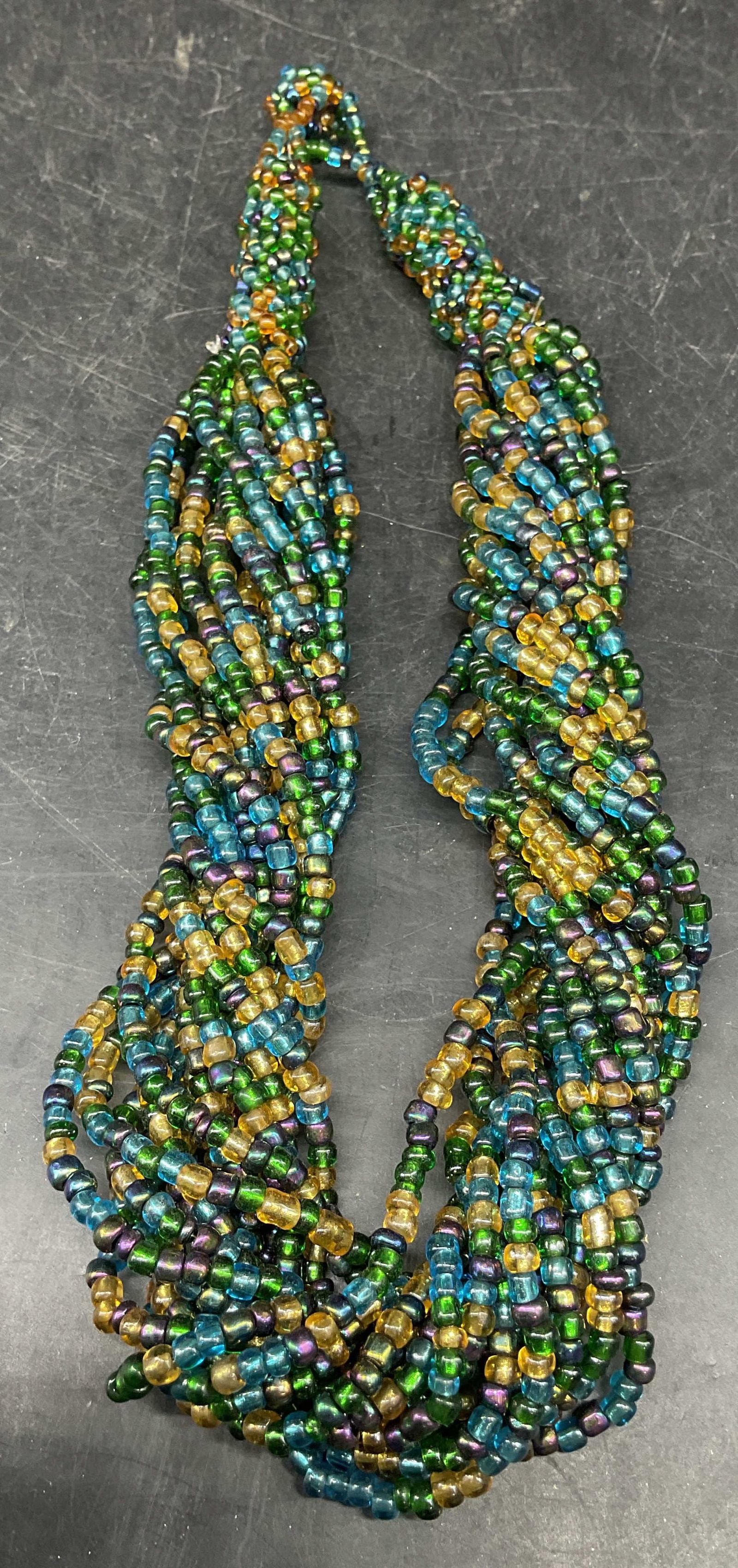 Twisted Multi Strand Blue Green Beaded Necklace: Twisted multi strand multicolor blue, green, yellow beaded necklace. Drop length measures approx. 8 inches. Some scratching. Jewelry, estate jewelry, costume jewelry, cocktail jewelry, fashion