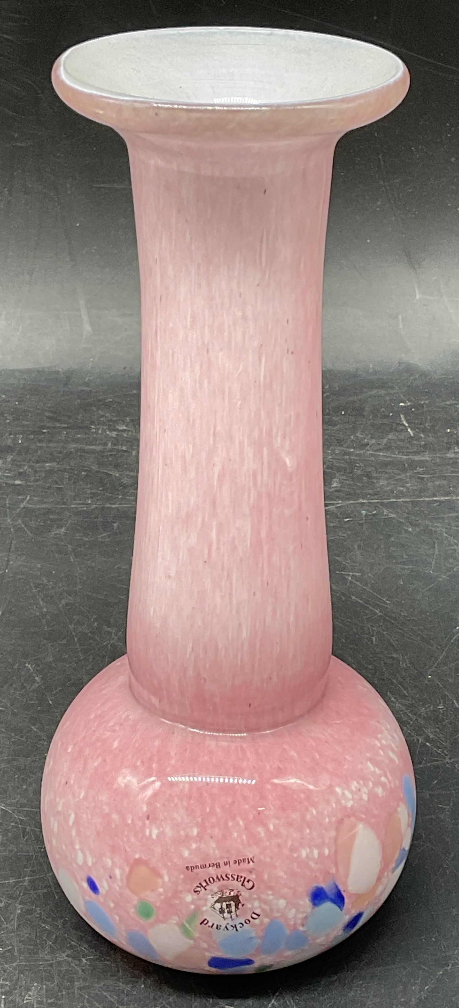 Dockyard Pink Confetti Art Glass Vase Bermuda: Signed Dockyard Glassworks hand blown pink confetti design art glass vase. Bulb shaped base with fluted rim. Made in Bermuda. Measures approx. 2.75 x 6.5 inches. Some scratching.
