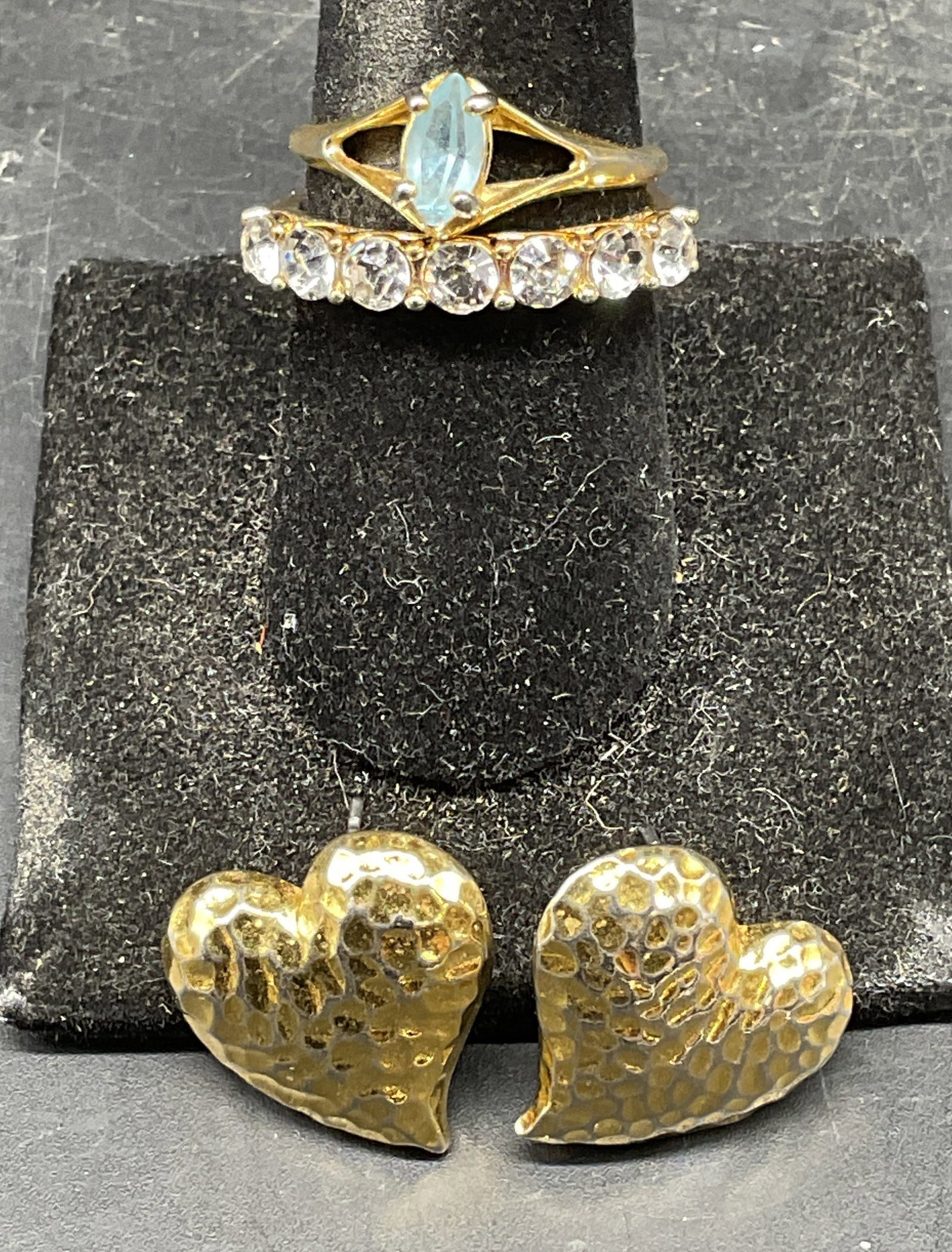 Lot 3 Gold Tone Crystal Rings & Heart Earrings: Lot of 3 gold tone rings and earrings. Heart earrings, measures approx. .75 inches long. Colorless crystal ring and blue crystal ring. Larger size 8. Some scratching. Jewelry, estate jewelry, costume 
