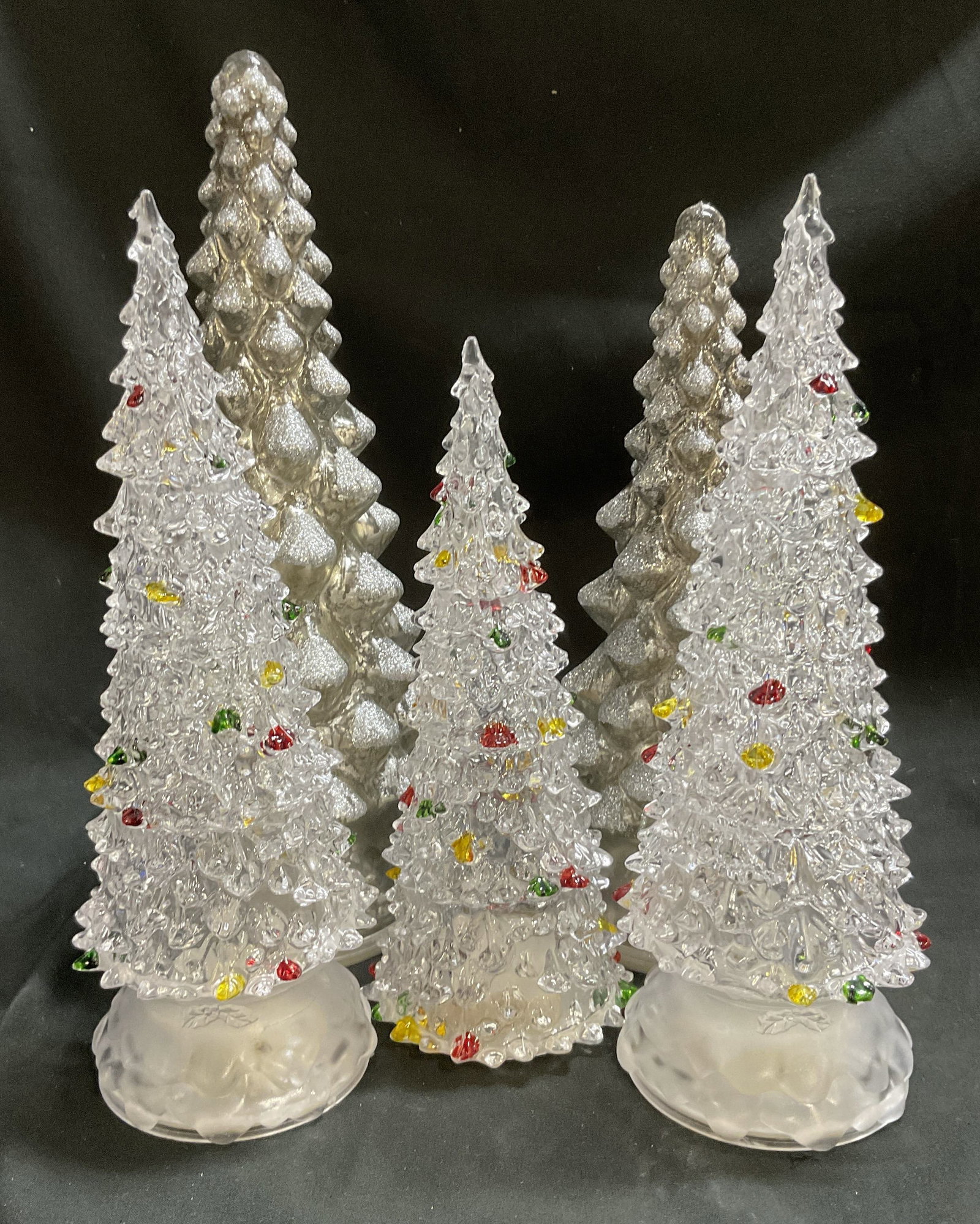 Lt 5 LED Light-Up White Christmas Trees: 5 LED Light-Up White Christmas Trees. Includes 3 Clear Acrylic Trees and 2 Glittery Mercury Glass Light-Up Trees. Lights up with Batteries. Not Tested for Functionality. Some Chips. Tallest Measures a
