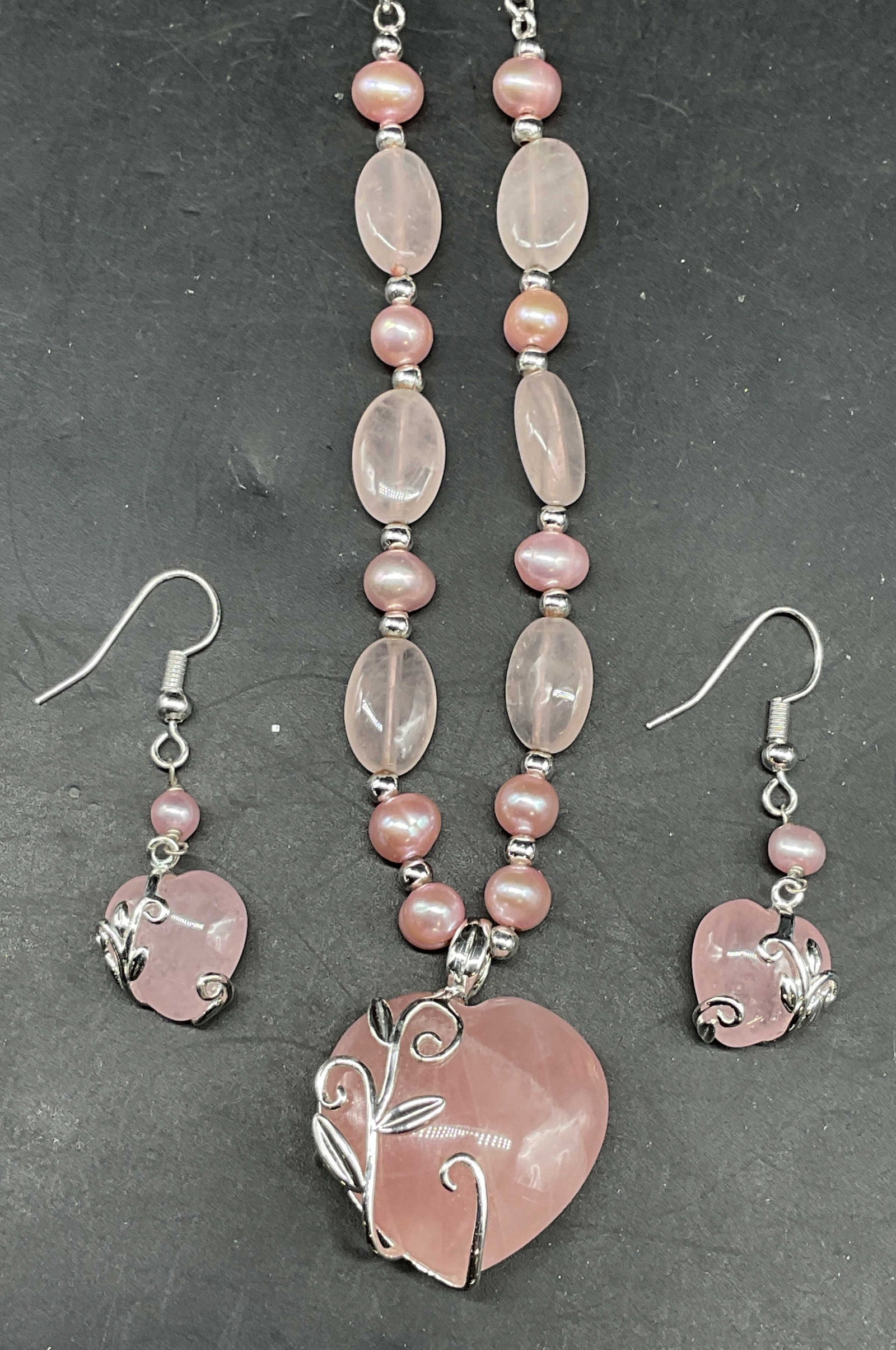 Lot 2 Pink Pearl Heart Necklace & Earrings: Lot of 2 matching jewelry pieces. Silver tone pink stone and pearl heart motif pendant necklace and earrings. Necklace drop length 9.5 inches. Earrings measures approx. 1 inch long. Some scratching. J