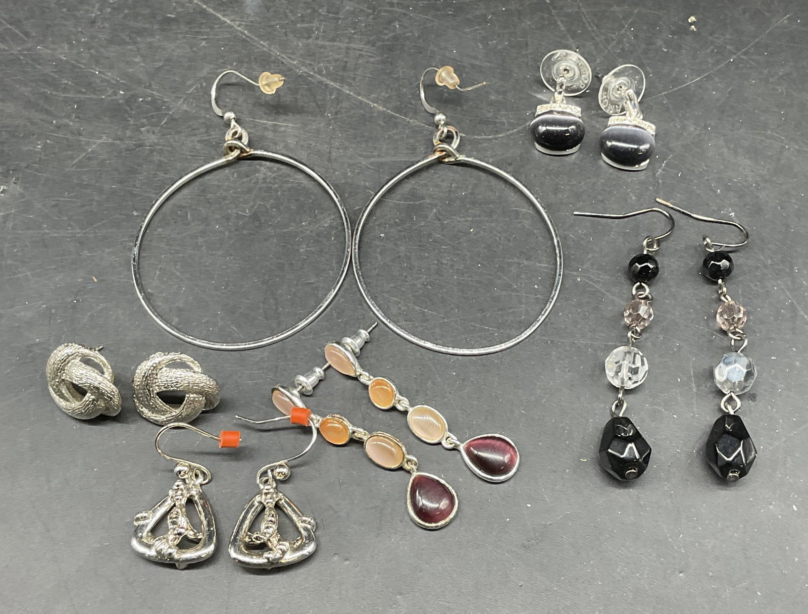6 Disney Tigger Earrings, Roman Crystal Earrings: Lot of 6 pairs earrings. Signed Disney Tigger earrings. Signed Roman Crystal earrings. Hoop earrings, black crystal earrings, purple crystal earrings, interlocking earrings. Largest measures approx. 2