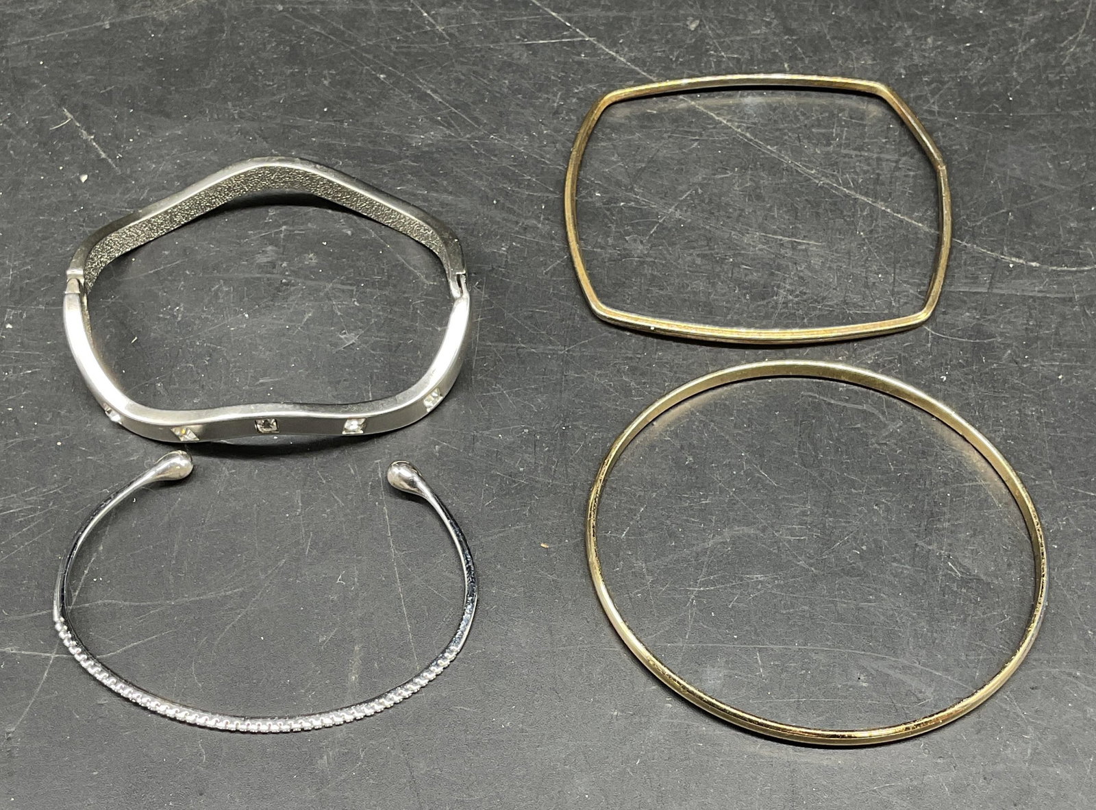 Lot 4 Silver & Gold Tone Bangle & Cuff Bracelets: Lot of silver and gold tone bangle and cuff bracelets. Silver tone bracelets with crystal accents. Largest measures approx. 2.5 inches wide. Some scratching. Jewelry, estate jewelry, costume jewelry, 