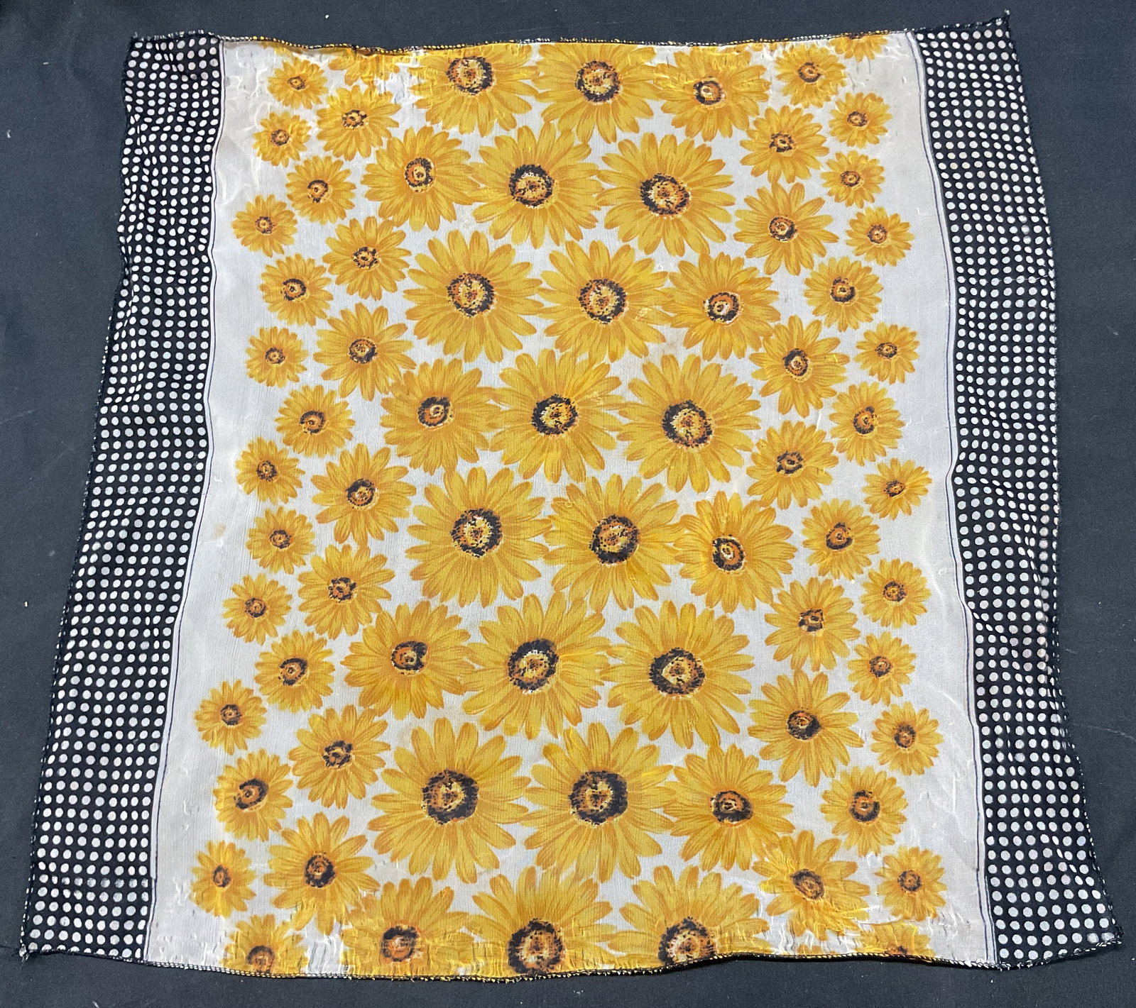 Vintage Sheer Sunflower Scarf: Vintage sheer sunflower scarf. Sunflower pattern in yellow and black. Polka dot pattern on either ends in black and white. Measures approx 18.5 x 19 inches. Wear consistent with exposure. Property of 