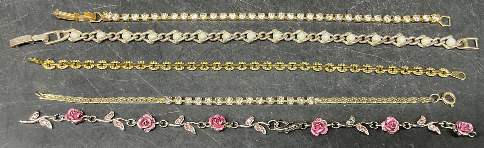 5 Silver & Gold Tn Crystal Faux Pearl Bracelets: Lot of 5 silver and gold tone bracelets with crystal enamel, and faux pearl decorations. Longest measures approx. 7.5 inches. One bracelet needs repair. Some scratching. Jewelry, estate jewelry, costu