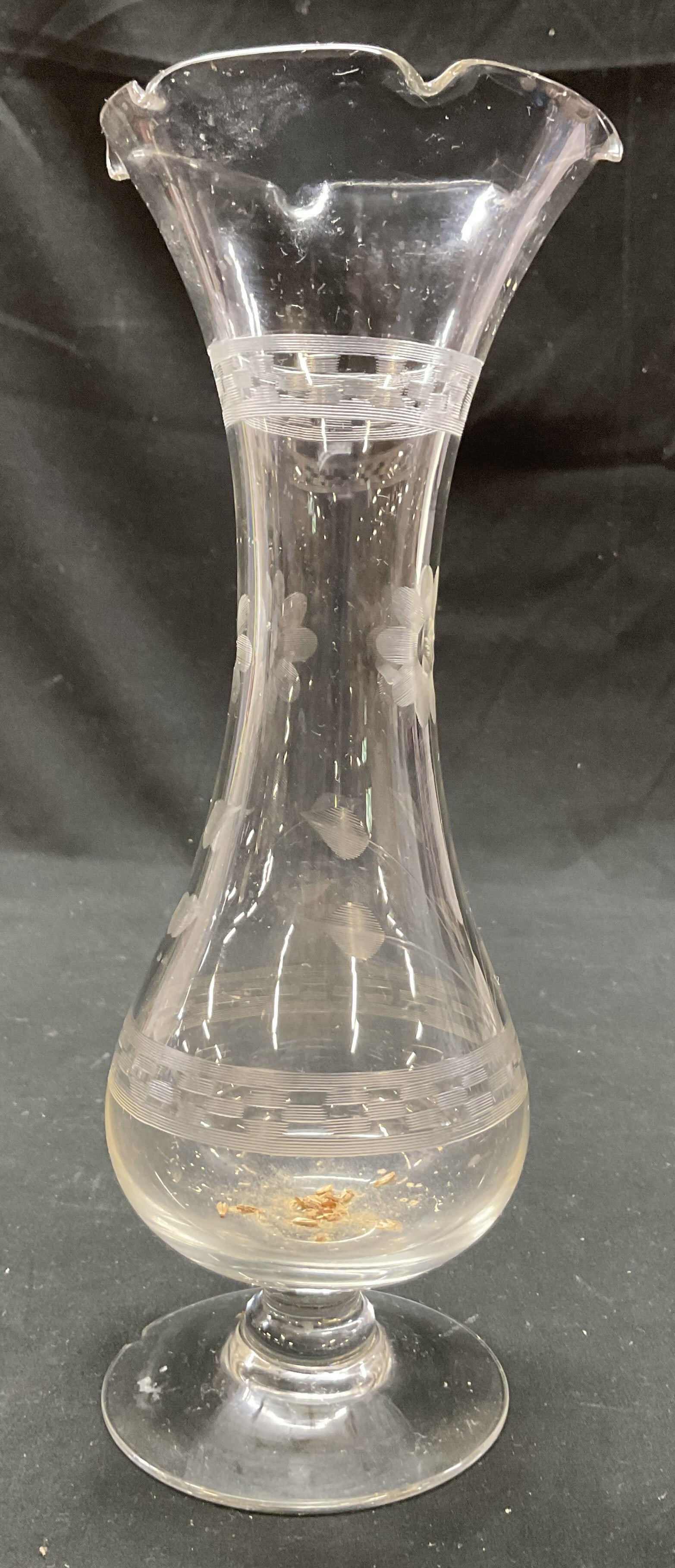 Vintage Hand Etched Glass Vase: Vintage hand etched glass vase. Round short pedestal base. Bulbous body and scalloped ruffled rim. Hand etched floral and geometric motifs. Measures ht approx 11 inches diam approx 4 inches. Some resi