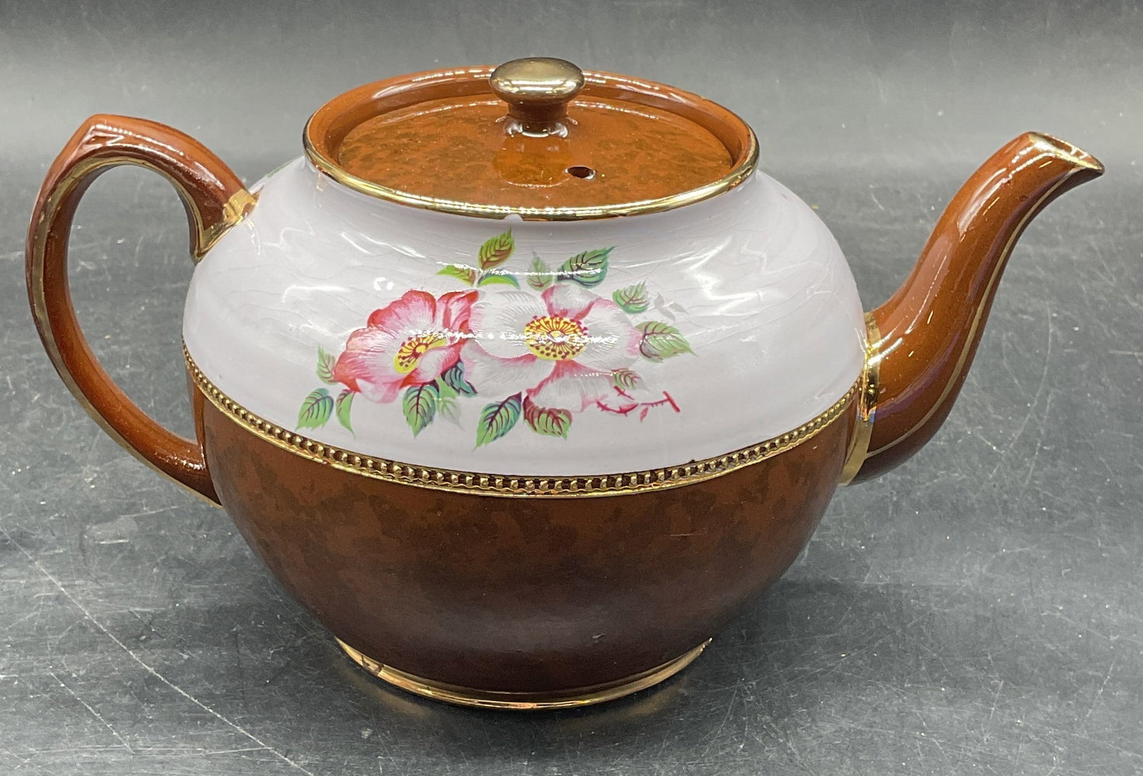 Sadler Ceramic Gilt Floral Teapot, England: Vintage Sadler ceramic teapot, hand painted floral design with gilt decoration. White and brown. Made in England. Measures approx. 9 x 5.75 x 4.75 inches. Some scratching and crazing. Sadler teapot, f