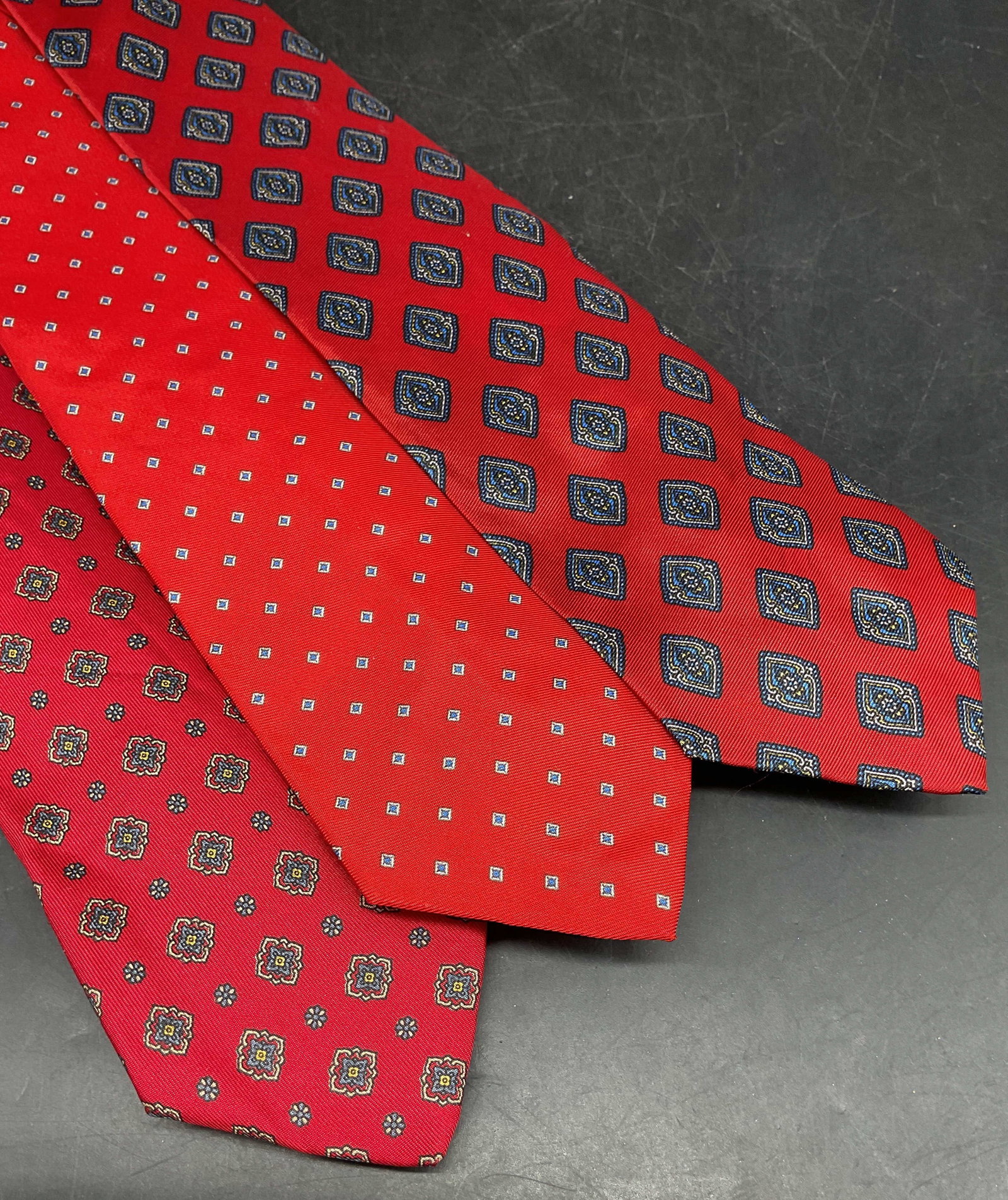Lot 3 Di Cori Aldo Red Geometric Silk Tie, Italy: Lot of 3 red geometric print ties. Di Coro Aldo silk tie, made in Italy. 2 Bancroft acetate ties. Longest measures approx. 55 inches. Some blemishes. Tie, silk tie, vintage tie, accessories, fashion a